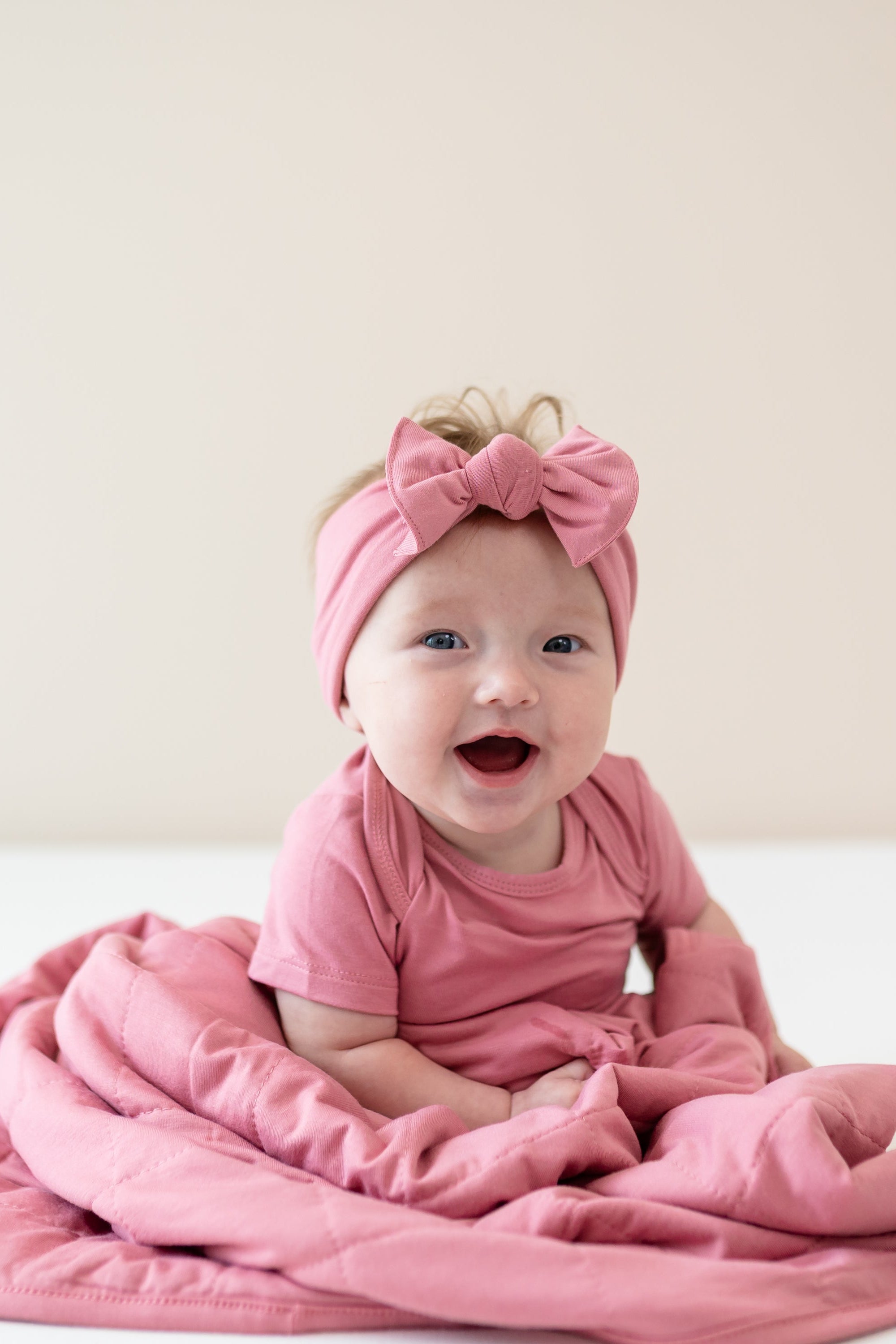 Infant wearing Apple Blossom Bodysuit and Bow wrapped in matching Baby Blanket in Apple Blossom TOG 1.0