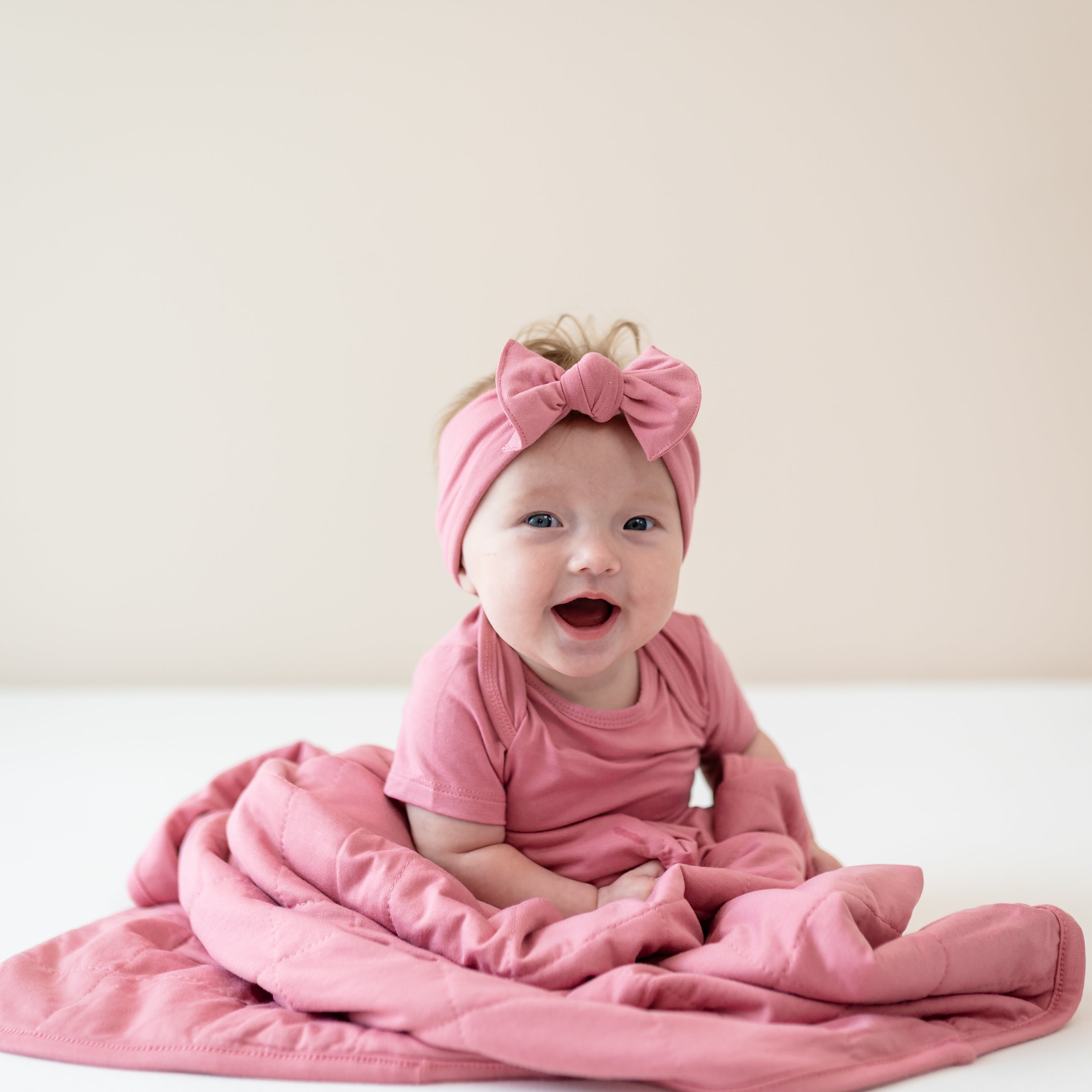 Infant wearing Apple Blossom Bodysuit and Bow wrapped in matching Baby Blanket in Apple Blossom TOG 1.0