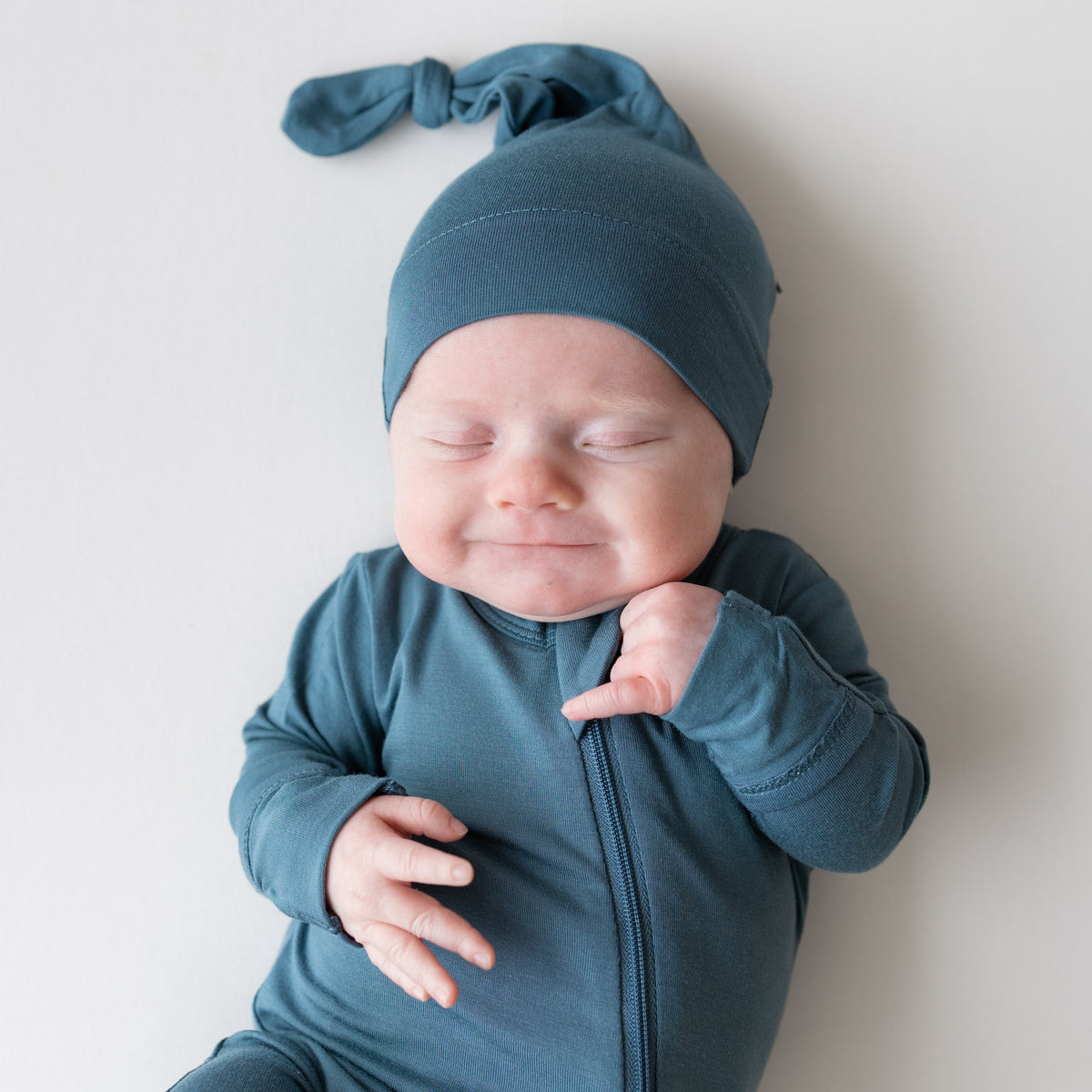 Baby wearing Knotted Cap in Atlantic and matching footie