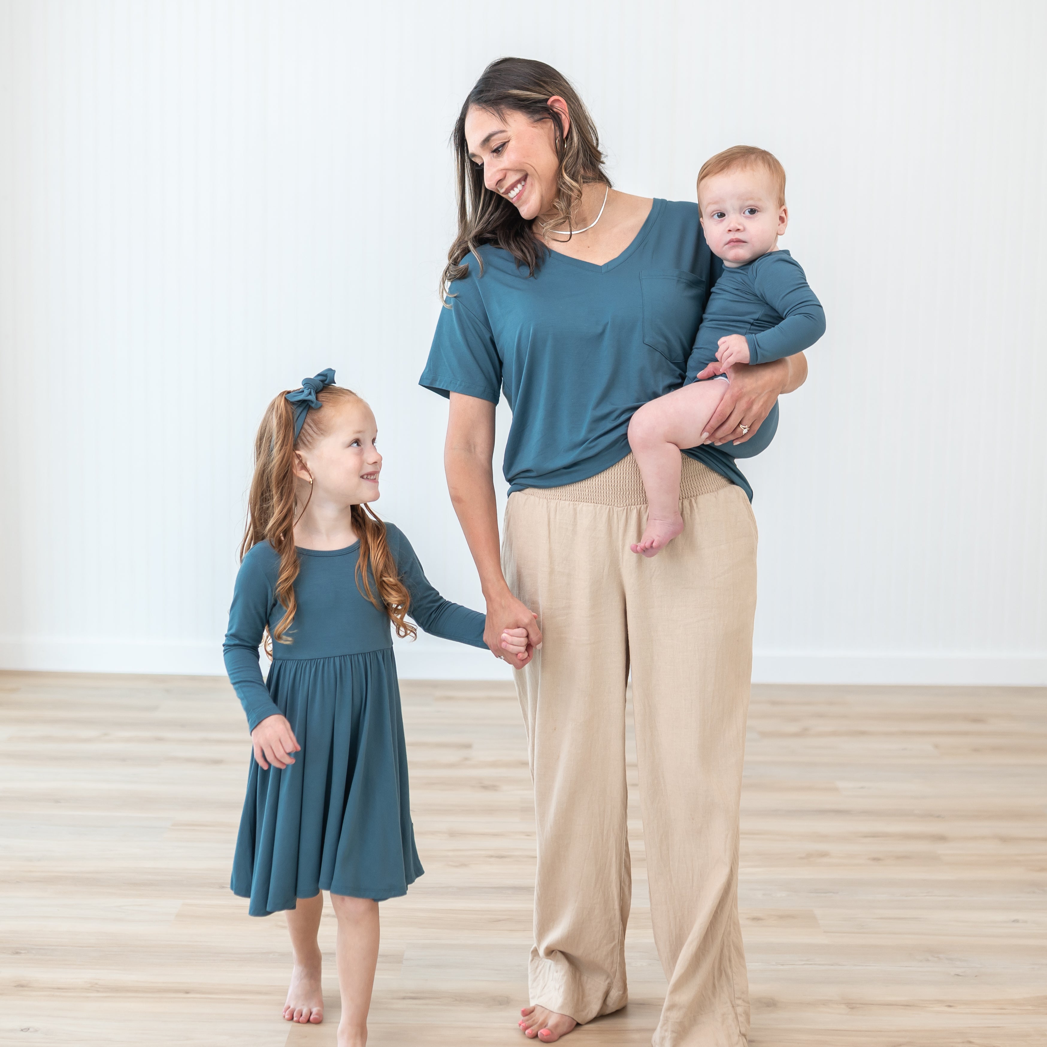 Family matching in Atlantic, oldest child is wearing a Long Sleeve Twirl dress and matching Knotted Bow Headband in Atlantic