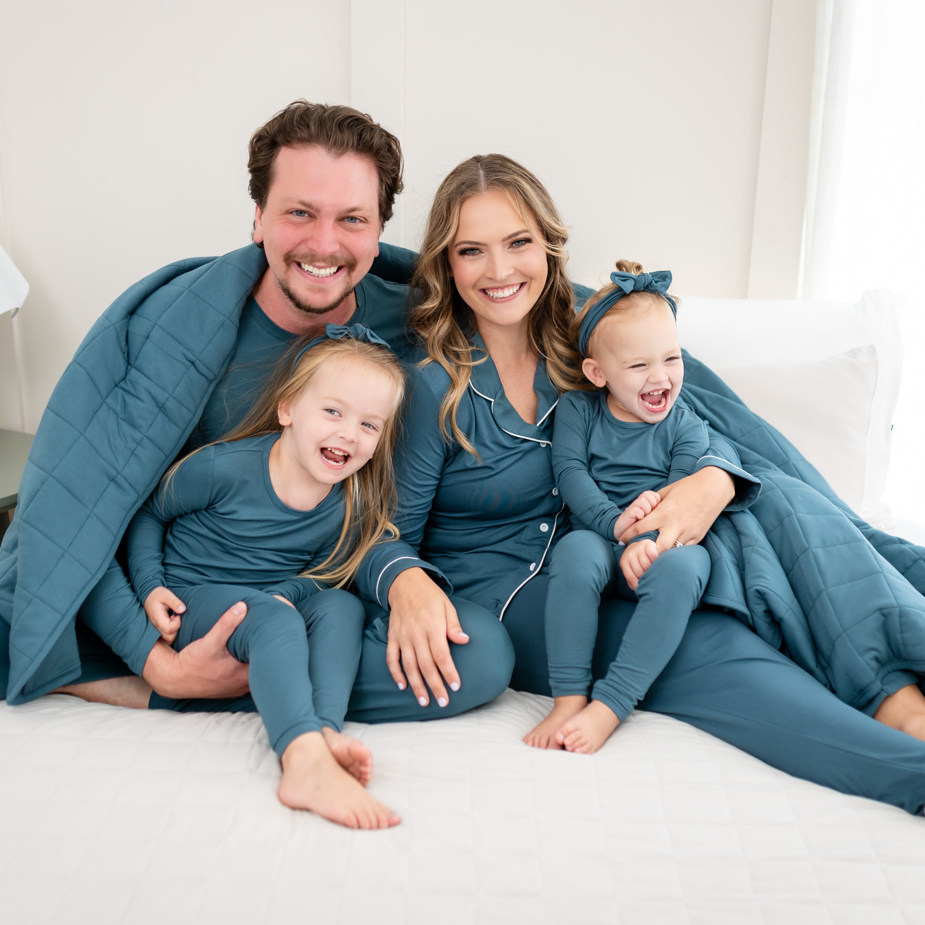 Family matching in various items in the color Atlantic. Youngest is wearing a Knotted Bow Headband in Atlantic as an accessory