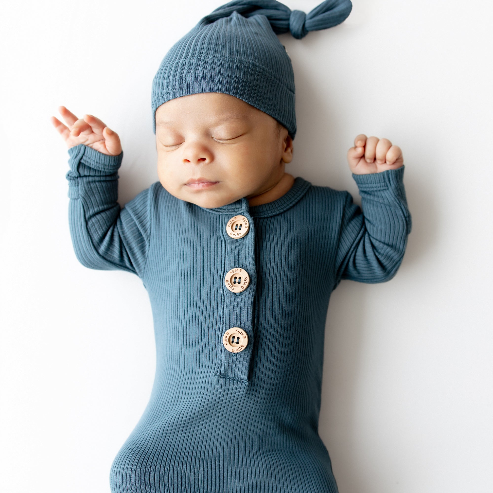Close up of sleeping infant wearing the Ribbed Knotted Gown with Hat Set in Atlantic
