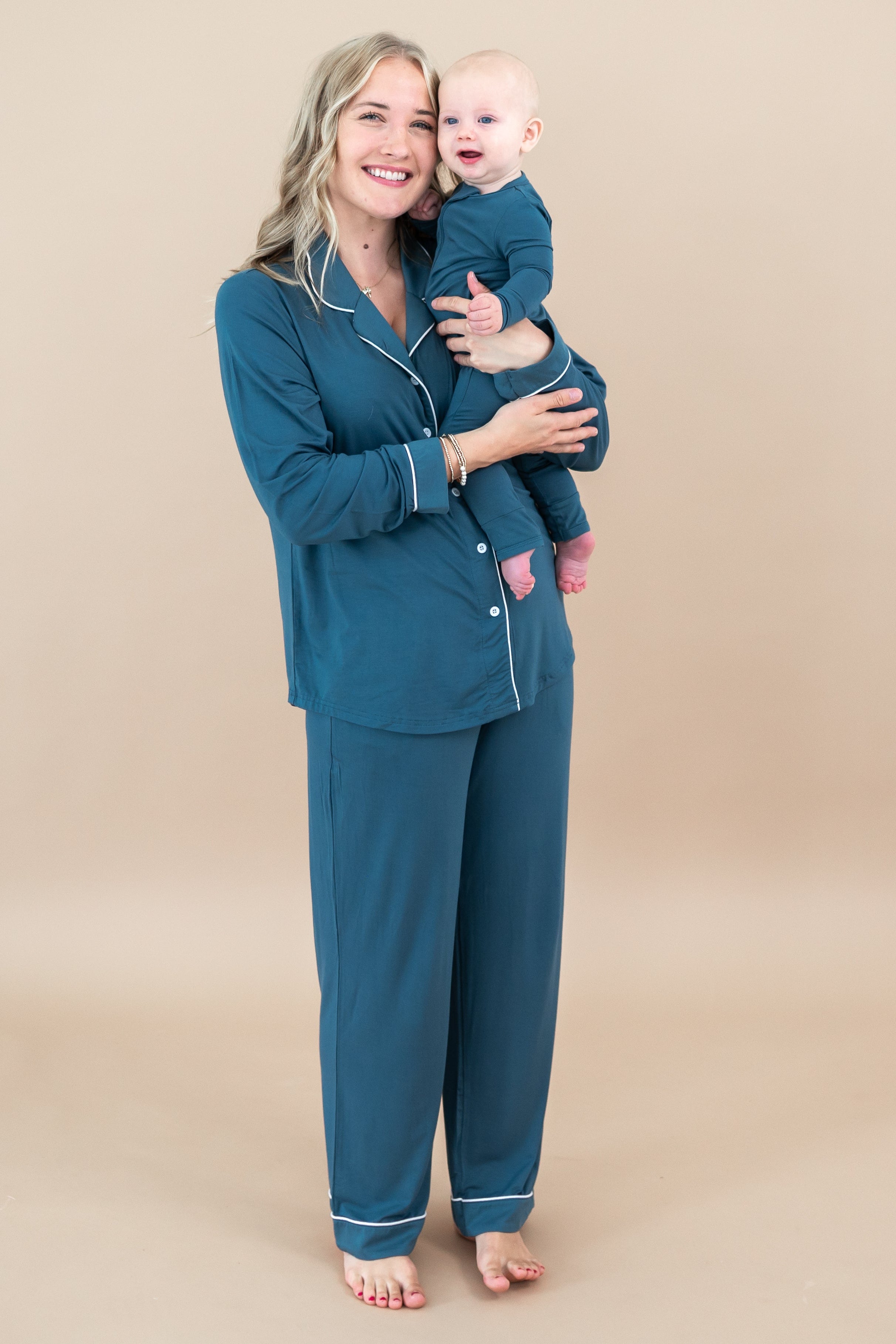 Mom and baby matching in Atlantic. Mother is holding infant wearing the Long-Sleeved Women's Pajama Set in Atlantic with Cloud Trim with the baby wearing the Zippered romper in Atlantic