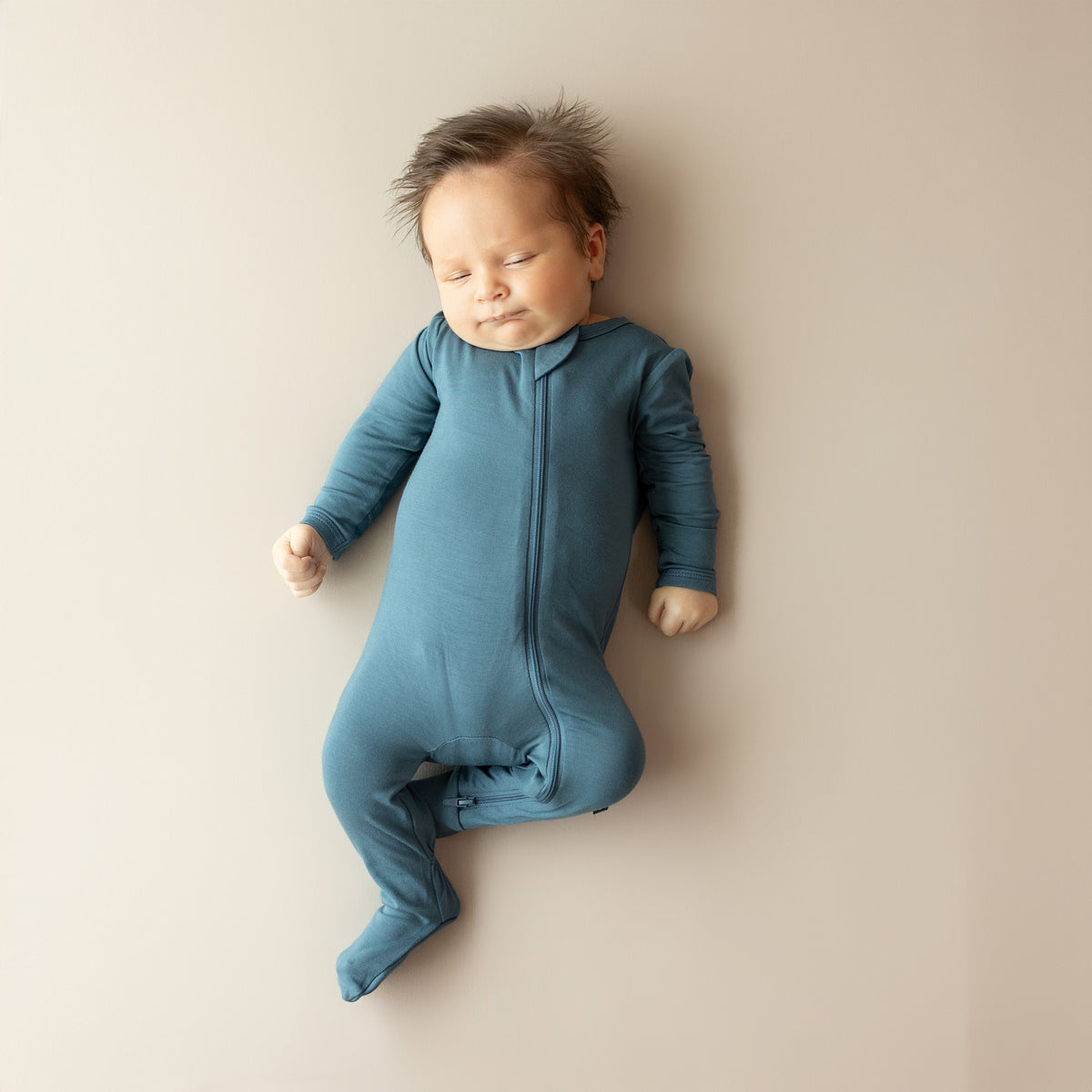 Sleeping infant wearing the Zippered Footie in Atlantic