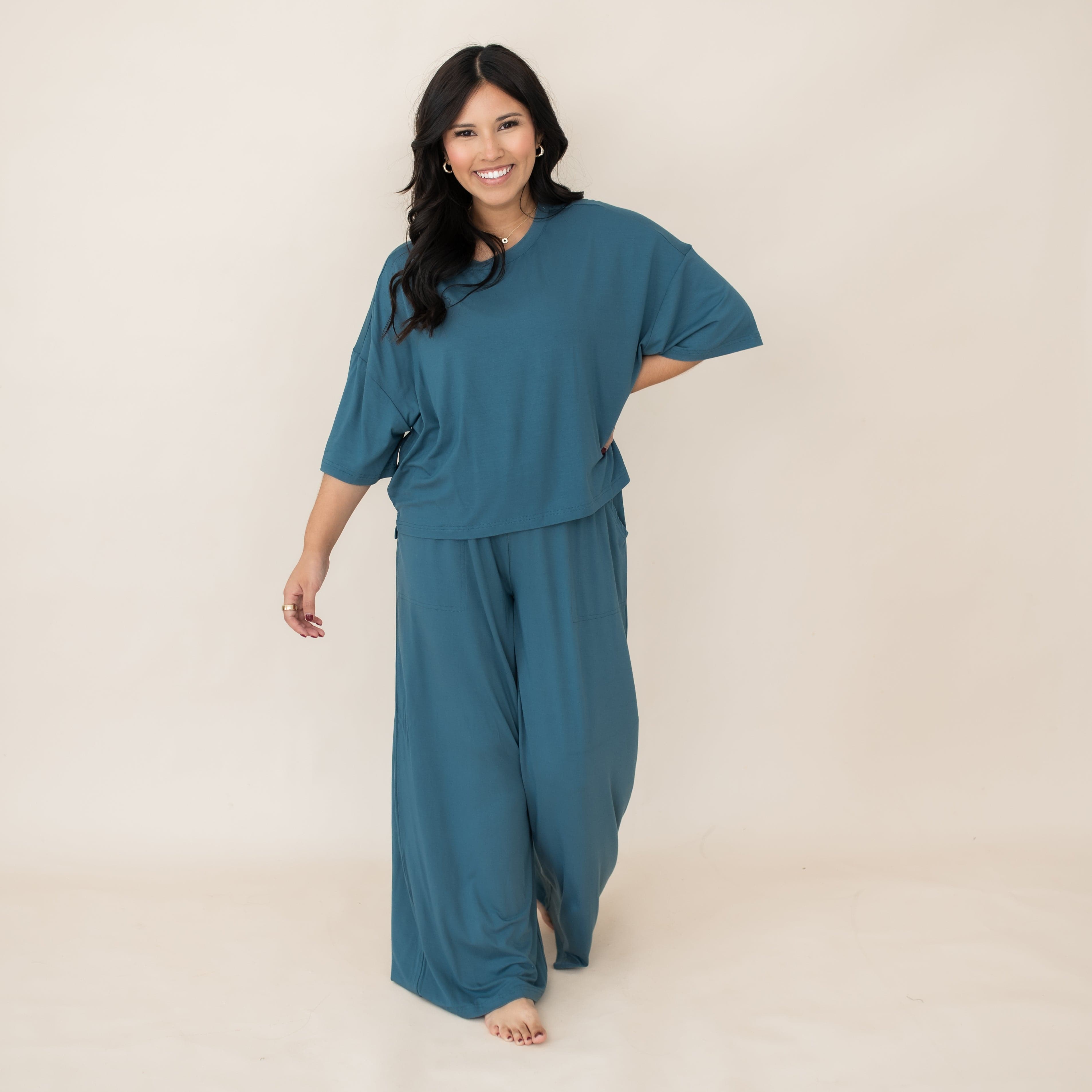 Smiling female walking wearing the Women’s Wide Leg Pant Set in Atlantic in front of a light neutral background