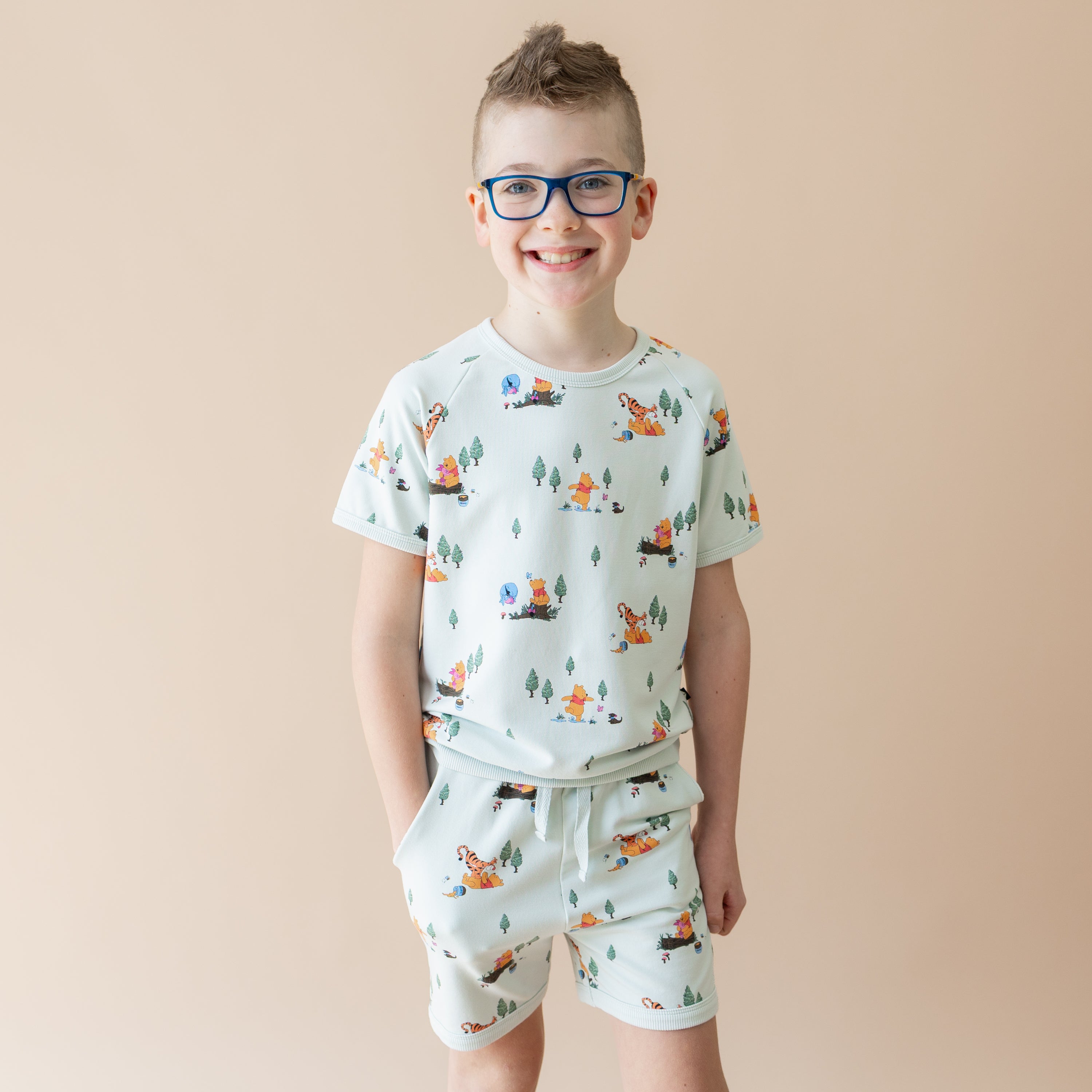 Young boy modeling the Short Sleeve Jogger Set in Winnie the Pooh Hundred Acre Wood