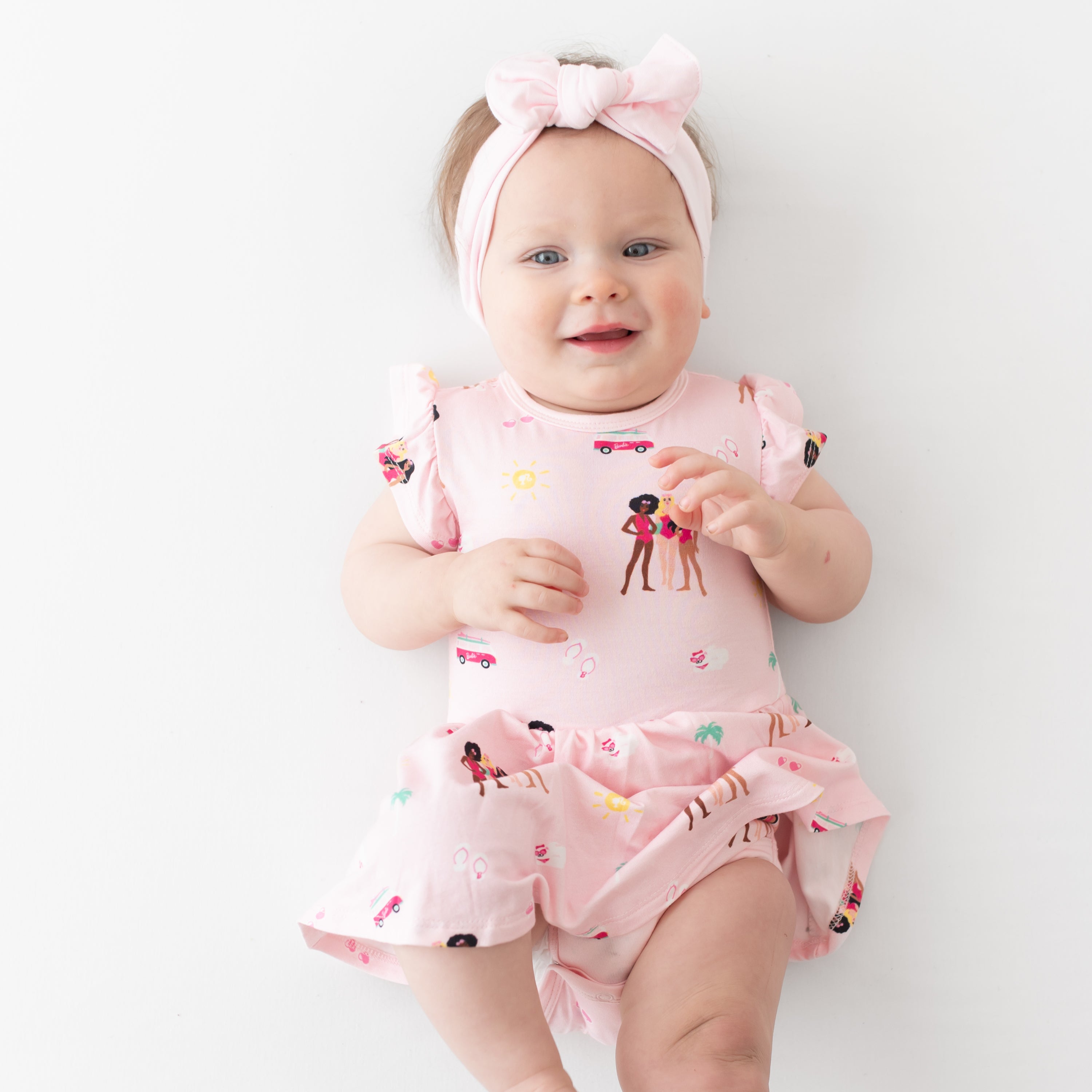 Baby wearing bamboo pink Twirl Bodysuit Dress in Barbie™ Beach