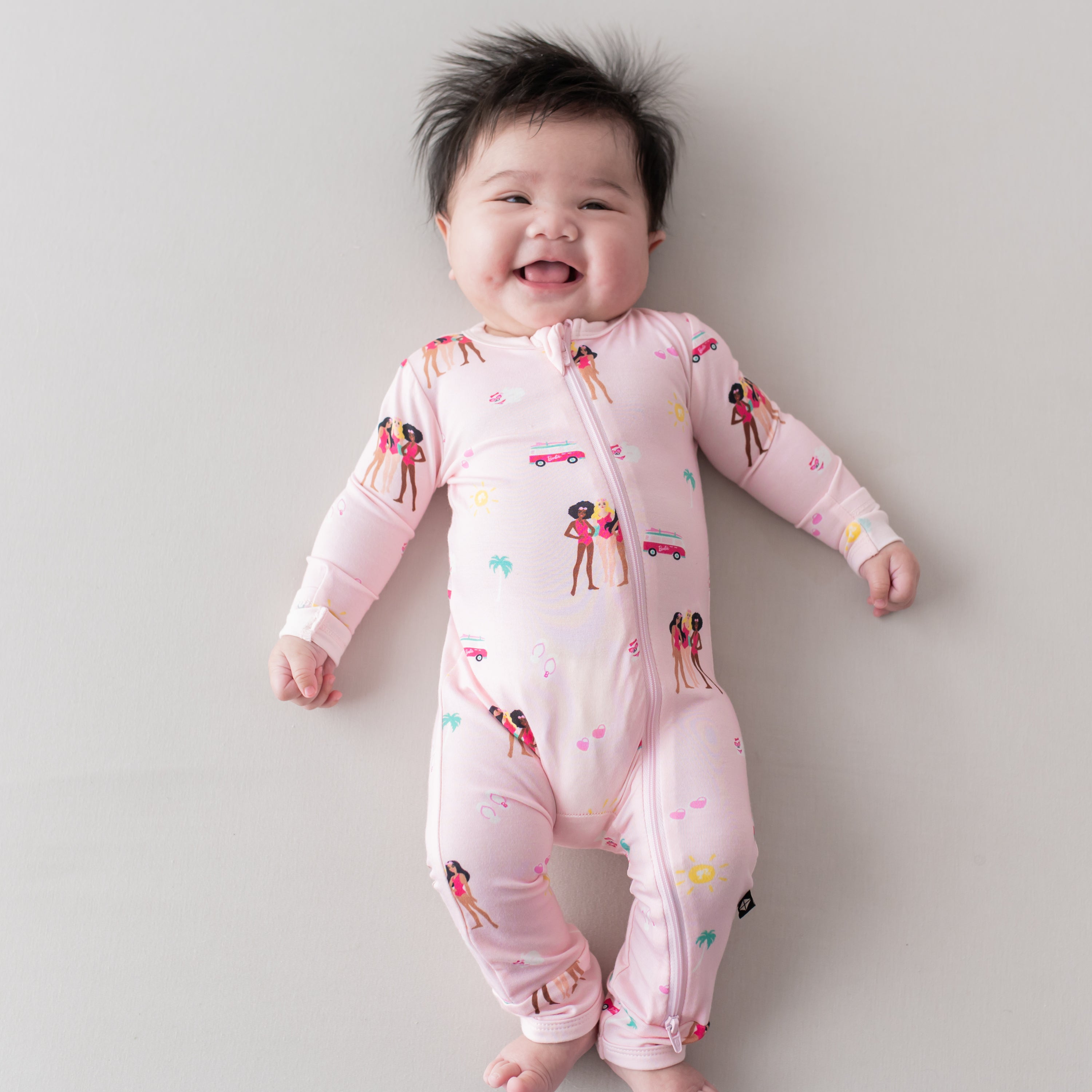 Infant wearing Kyte Baby Zippered Romper in Barbie™ Beach