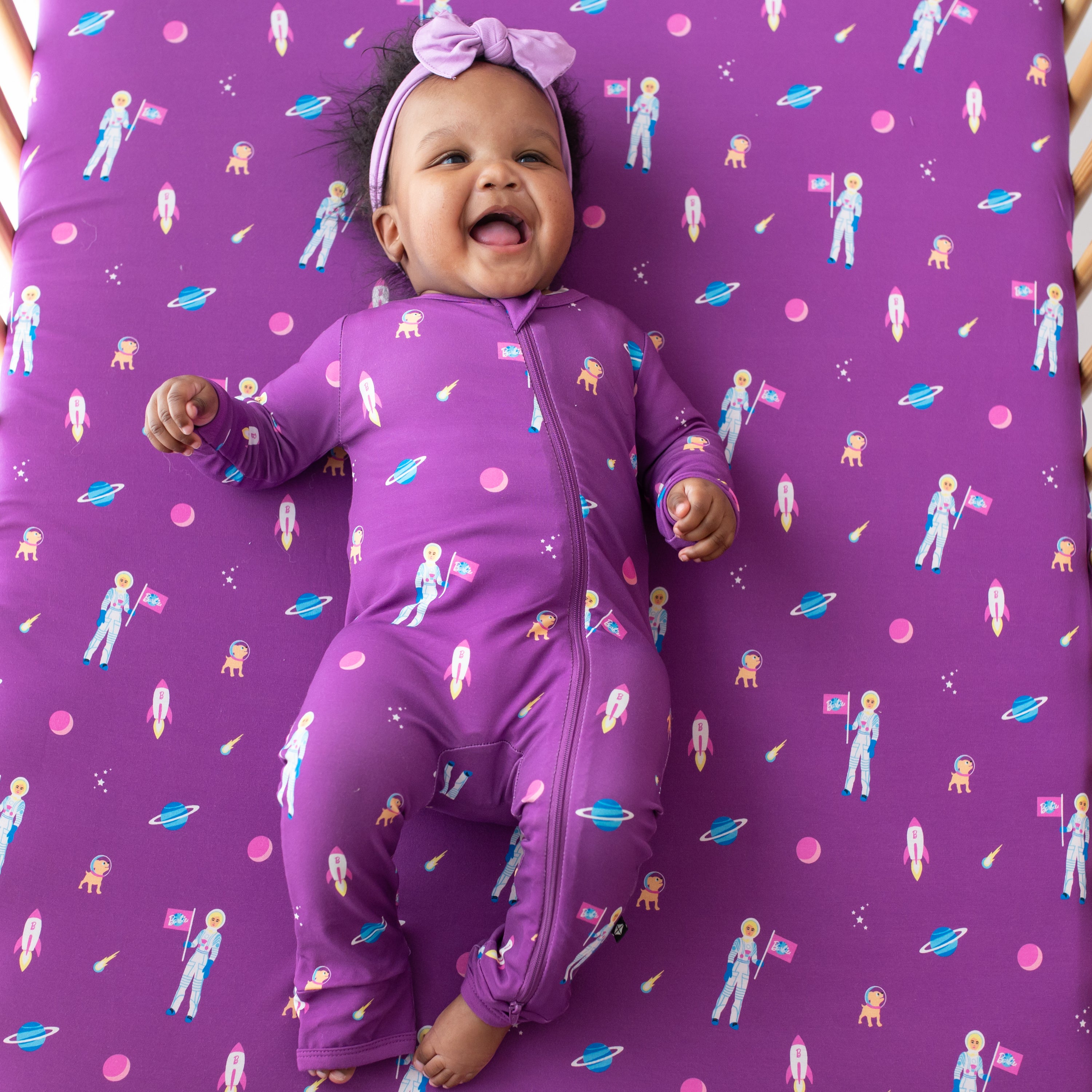 Infant wearing Kyte Baby Zippered Romper in Barbie™ Astronaut