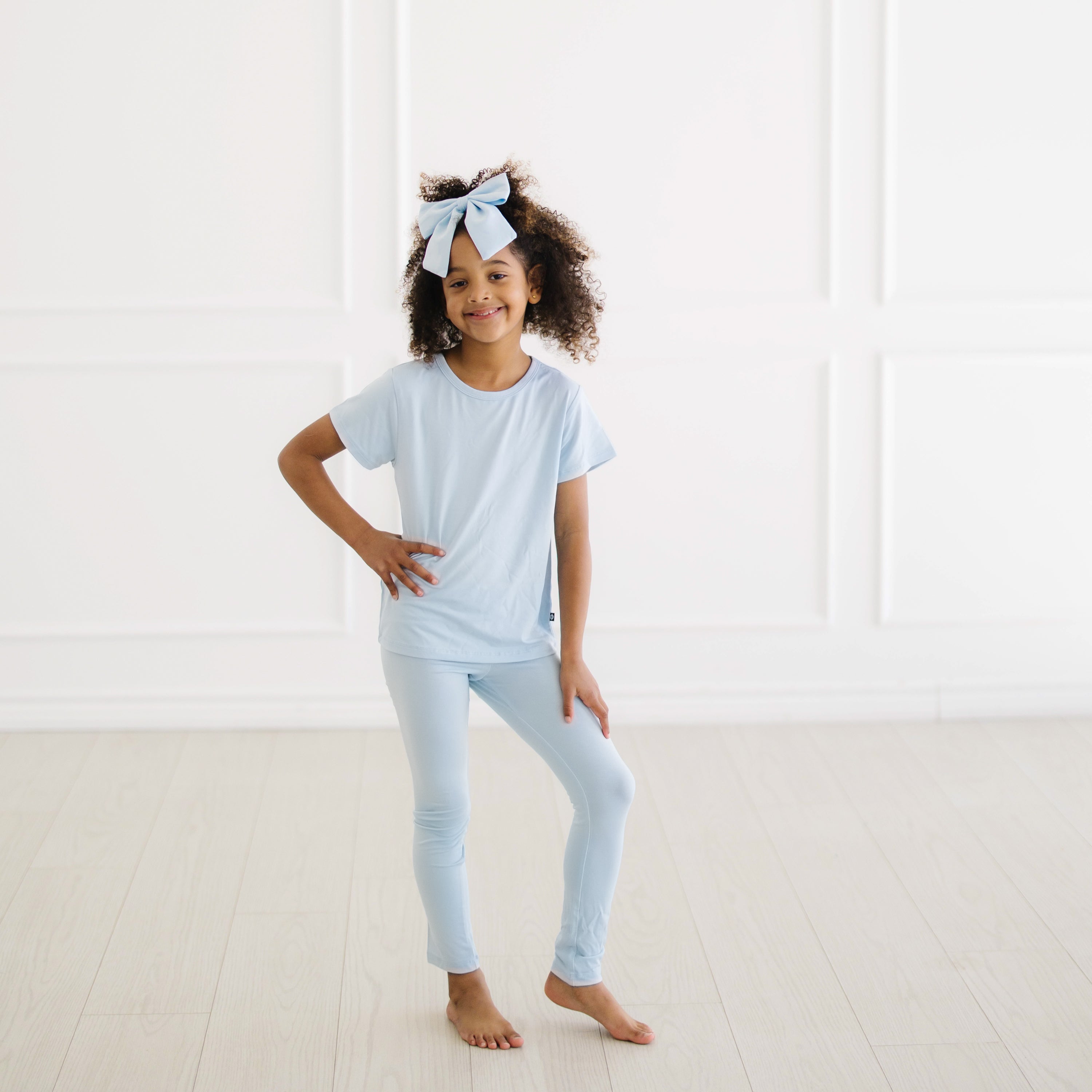 Young girl posing wearing the Toddler Basic Tee in Breeze with matching leggings