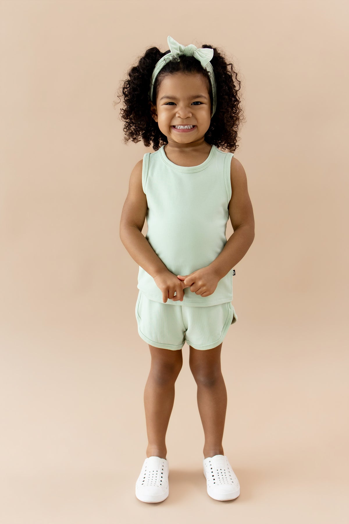 Young smiling girl wearing the Tank Jogger Set in Basil