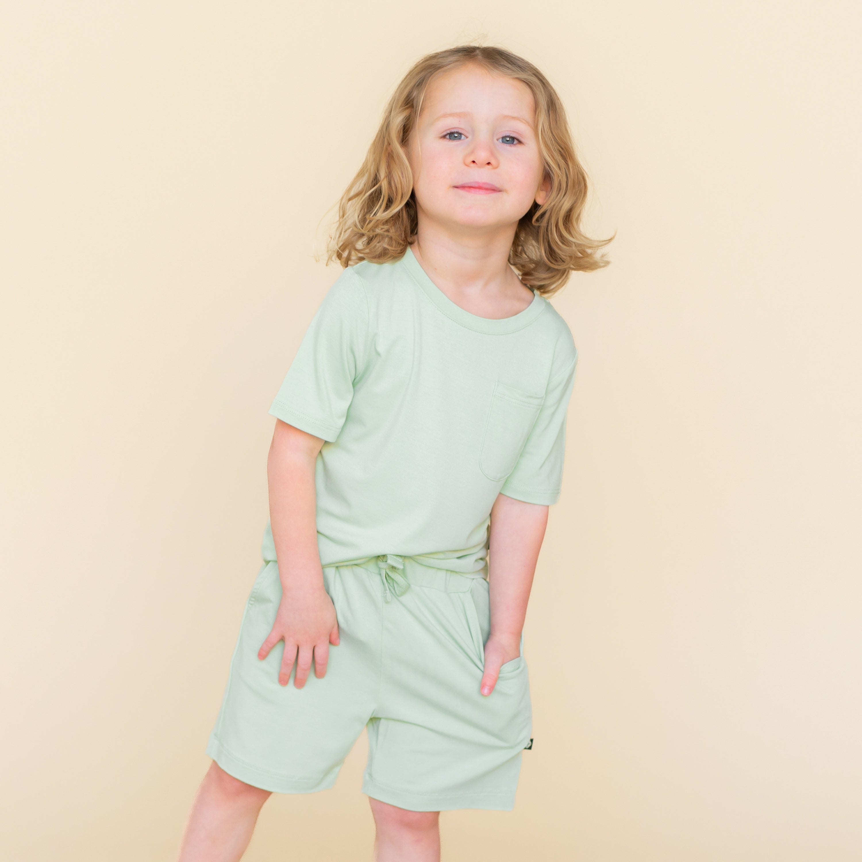 Young child wearing the Drawstring Short in Basil with matching toddler crew neck tee