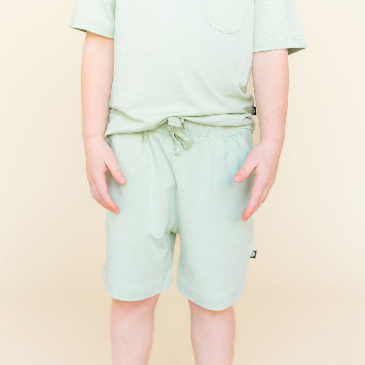 Close up of the Drawstring Short in Basil shown on a young model