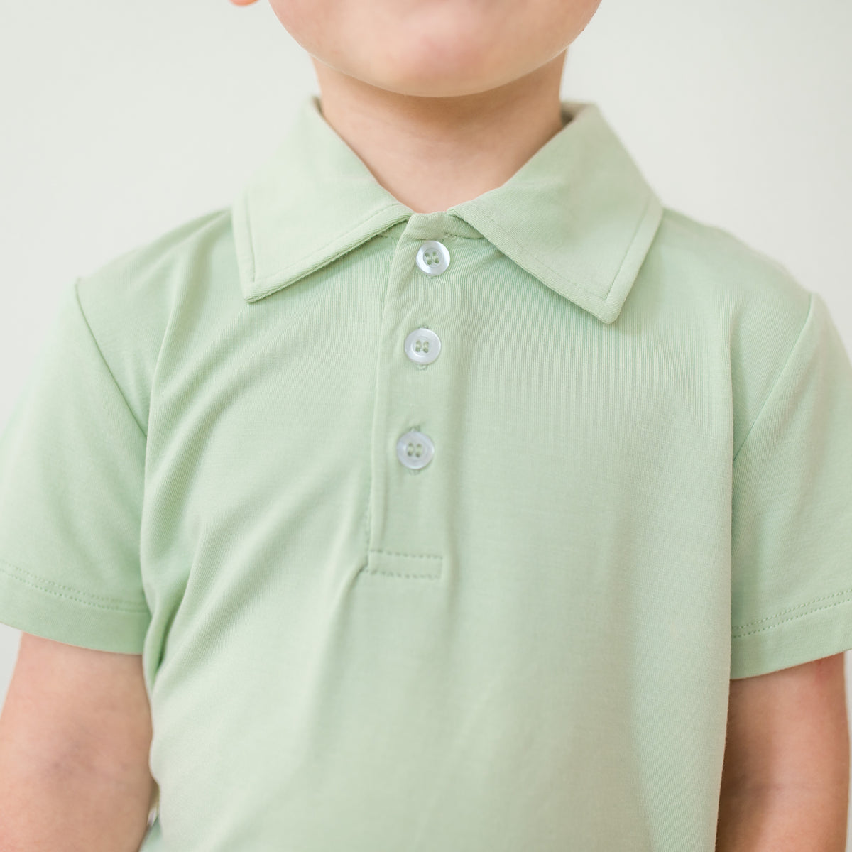 Light green polo shirt worn by a child on a plain background