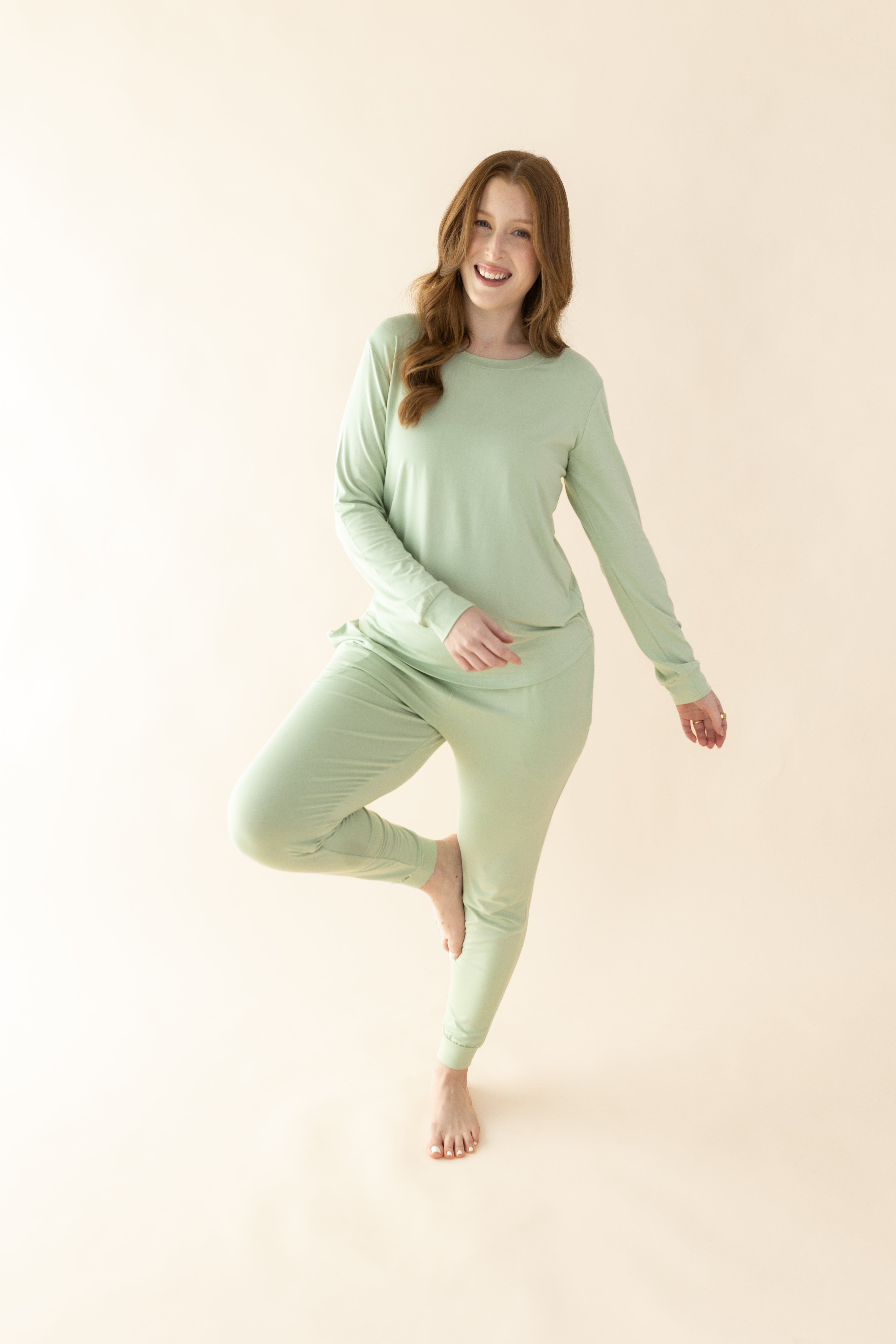 Female posing wearing the Women's Jogger Pajama Set in Basil in front of a light neutral background