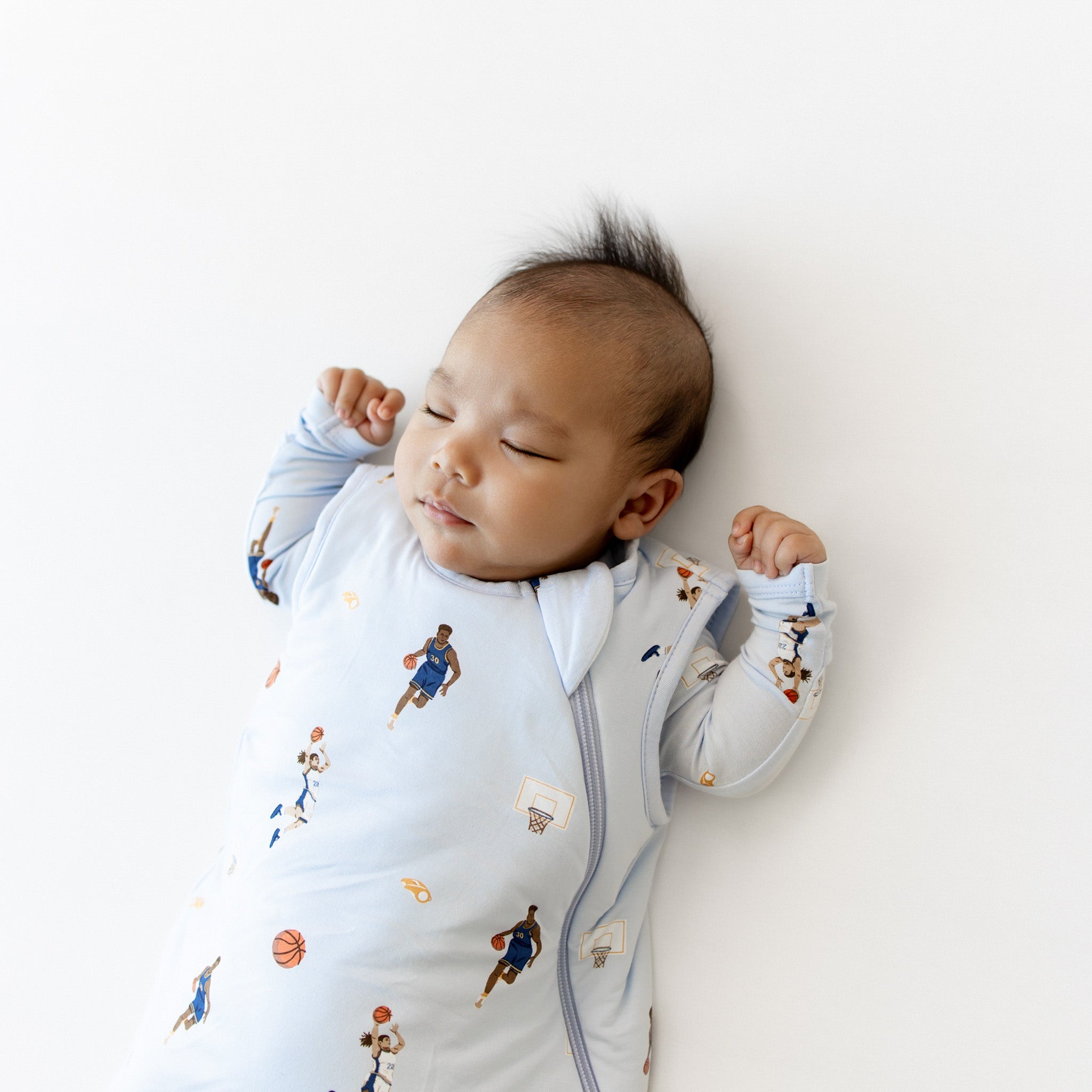 Close up of sleeping baby wearing the Sleep Bag in Basketball 1.0