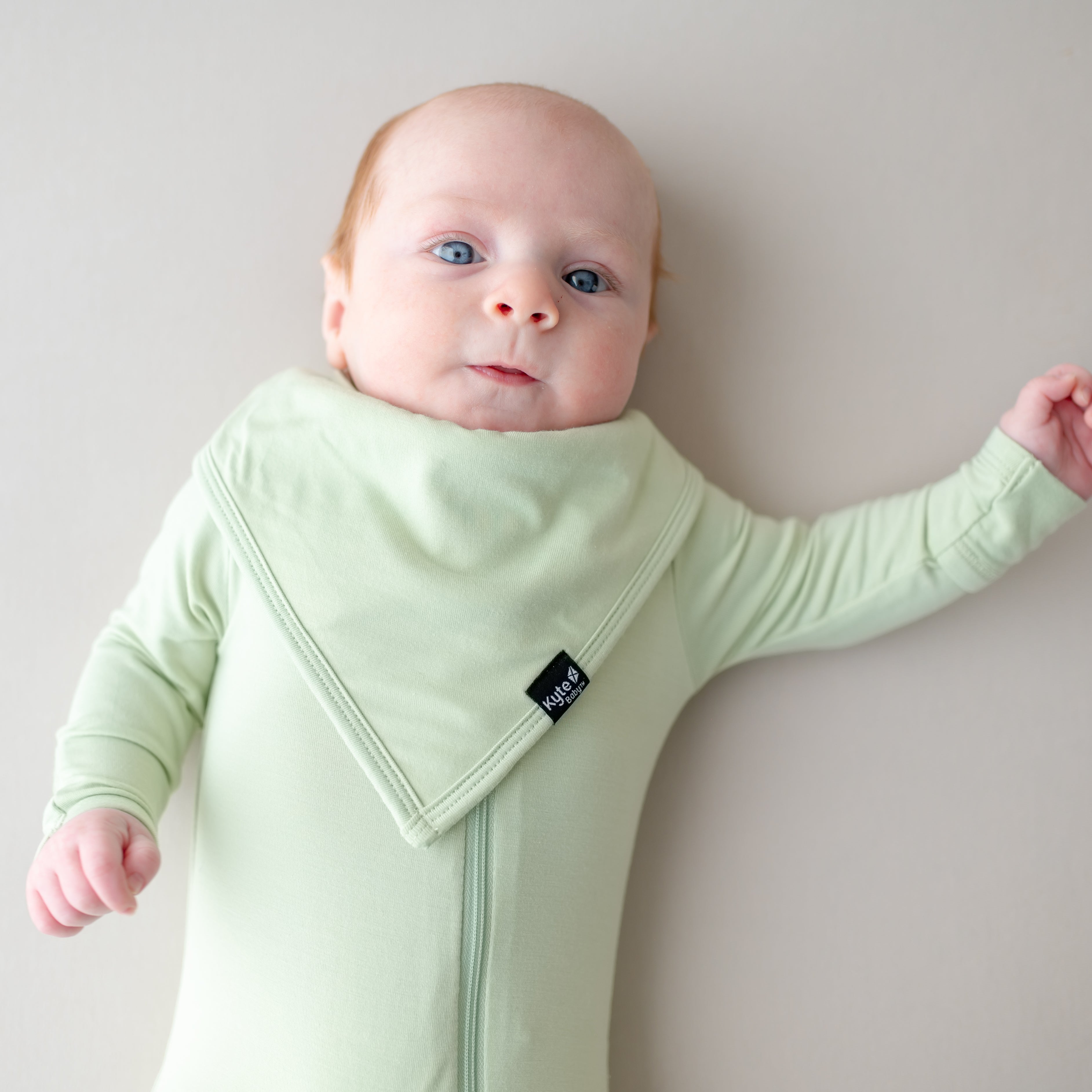 Baby wearing a light green outfit and matching green bib
