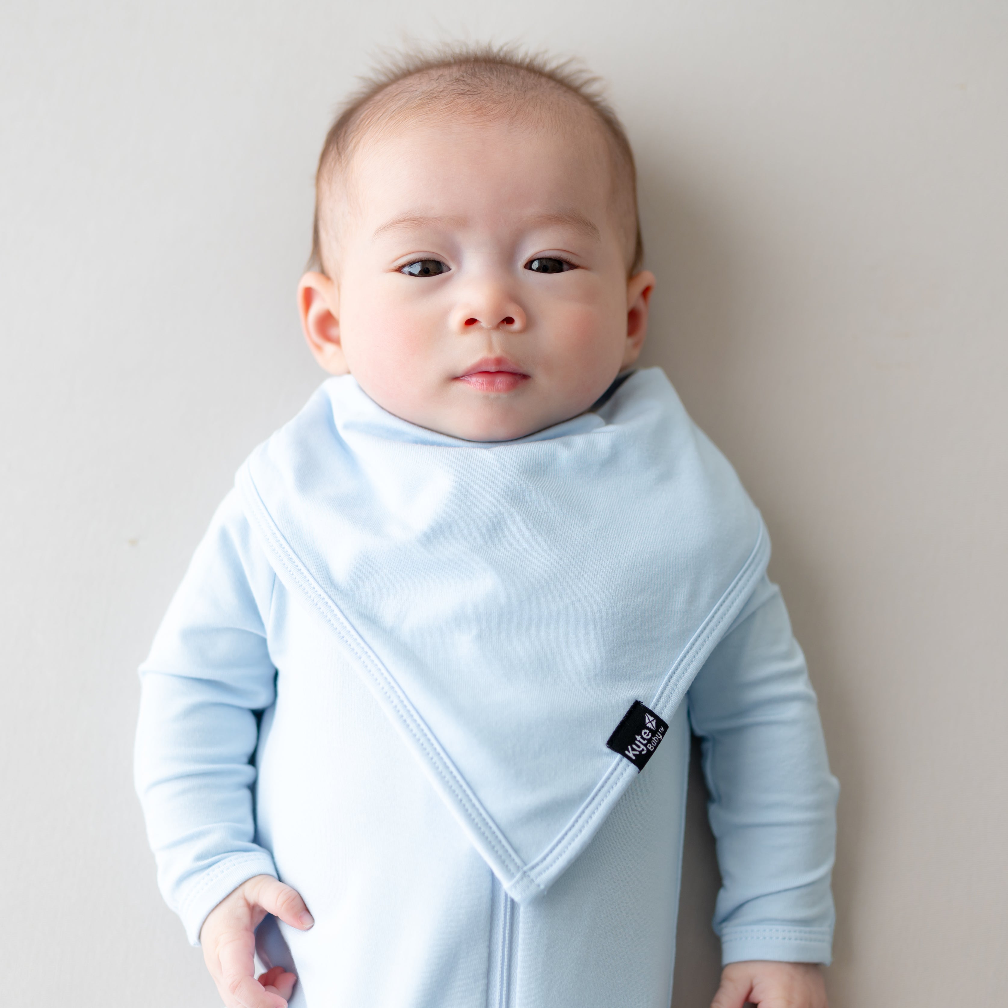 Baby wearing light blue outfit and matching bib