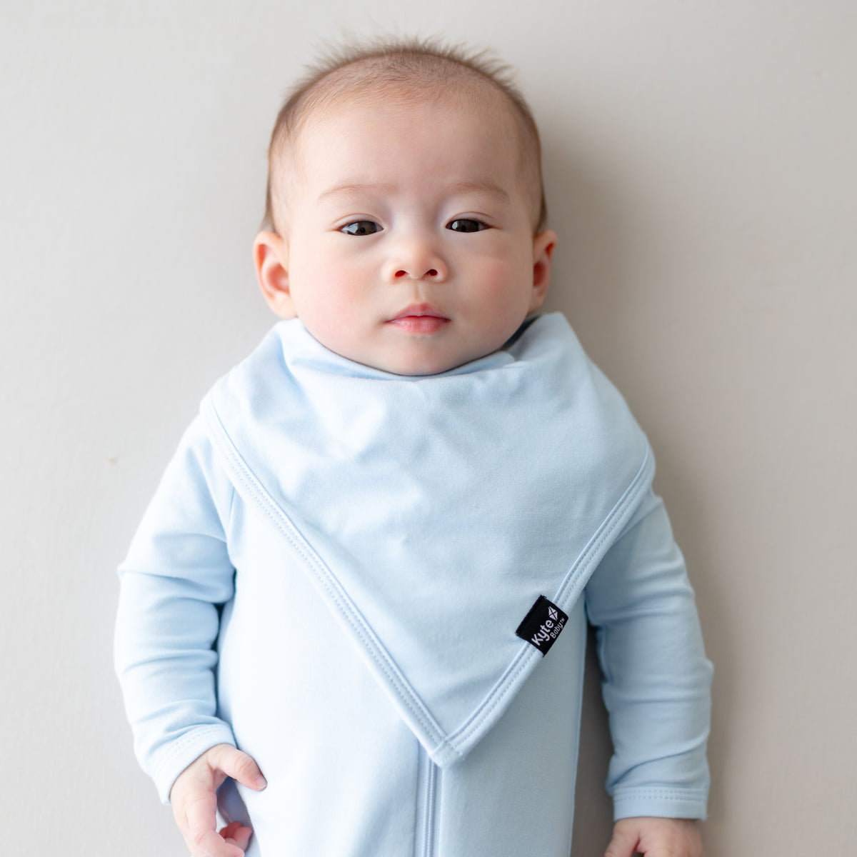 Baby wearing light blue outfit and matching bib