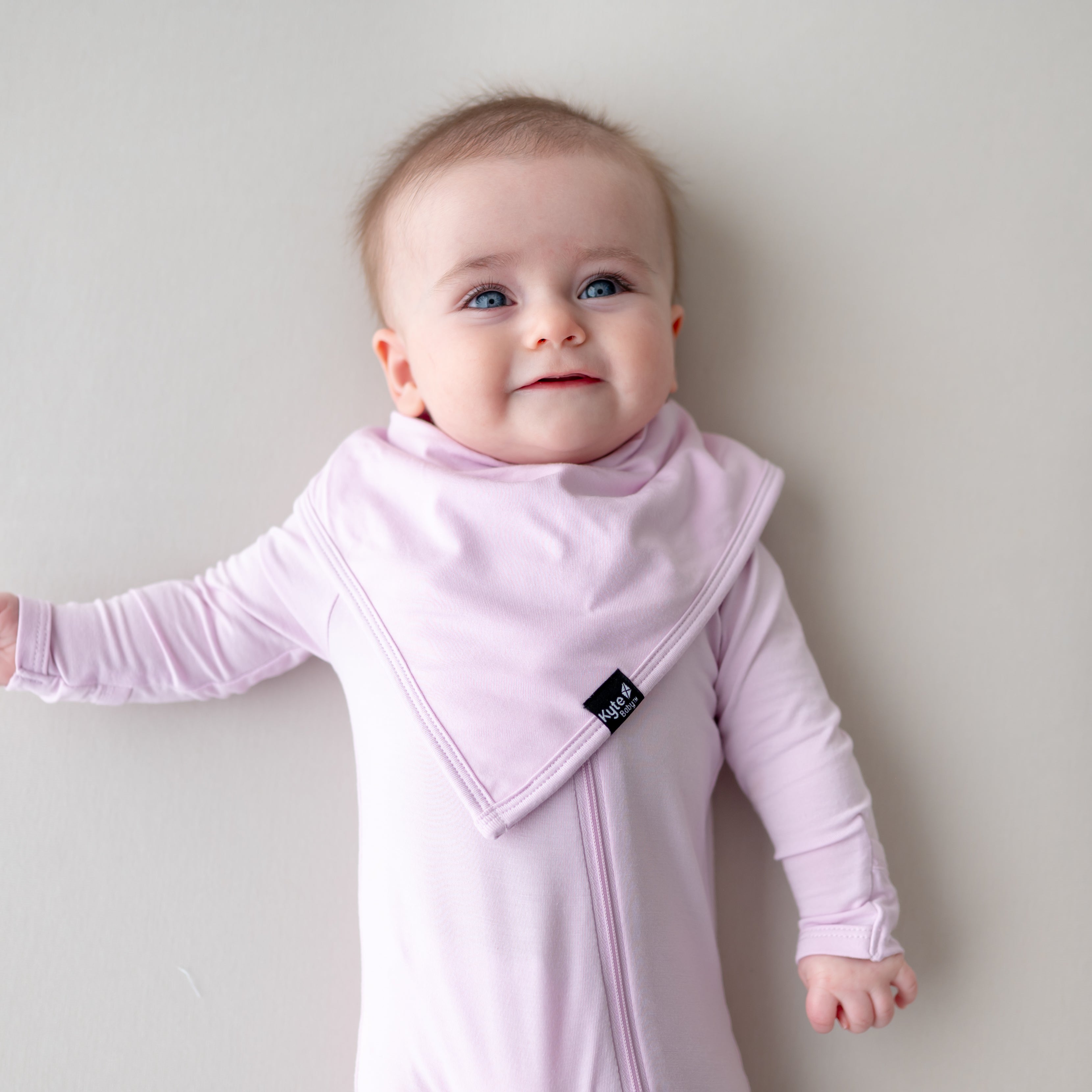 Baby wearing a light purple bib and matching outfit