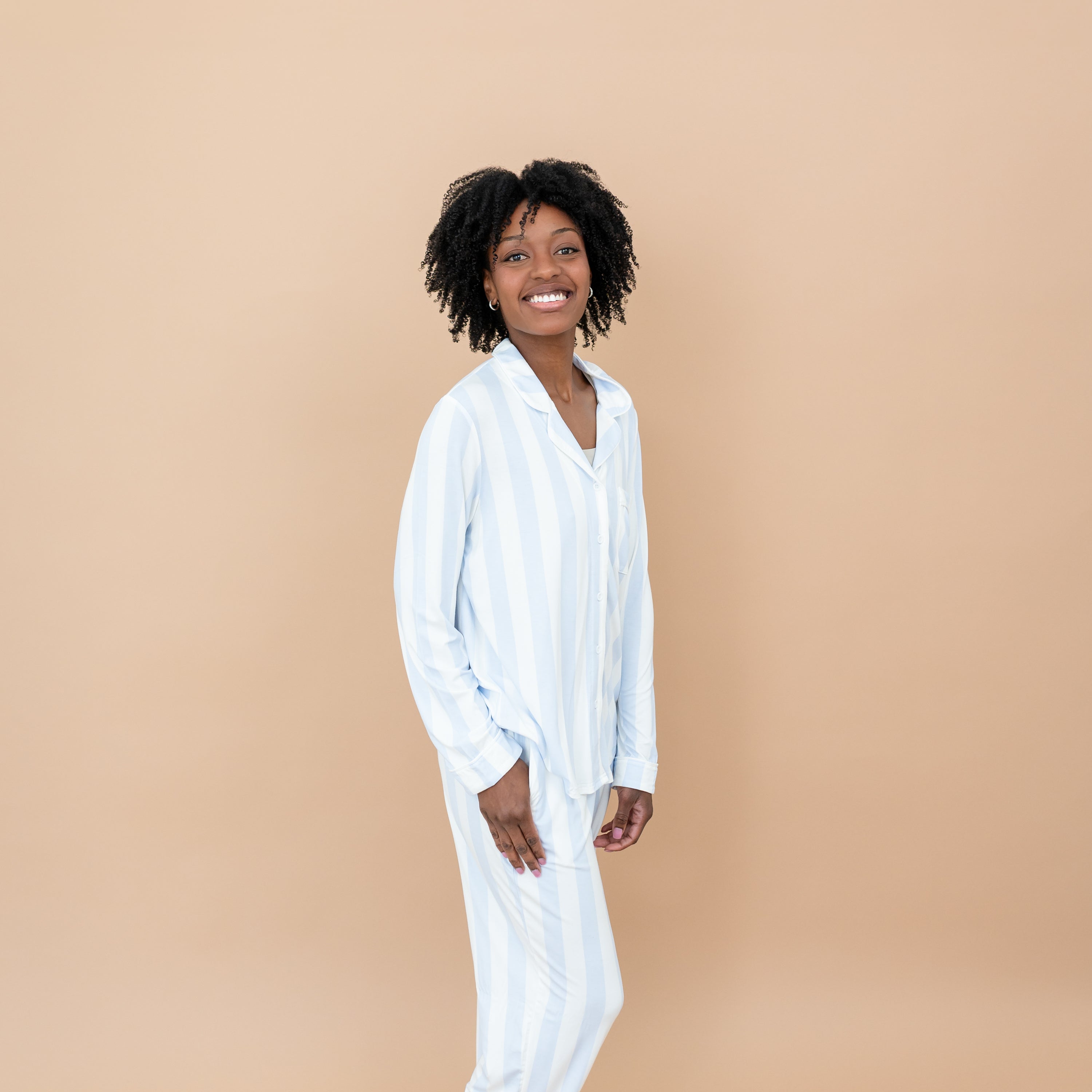Smiling female model wearing the Long-Sleeved Women's Pajama Set in Big Mist Stripe with one hand in the pocket of the pants
