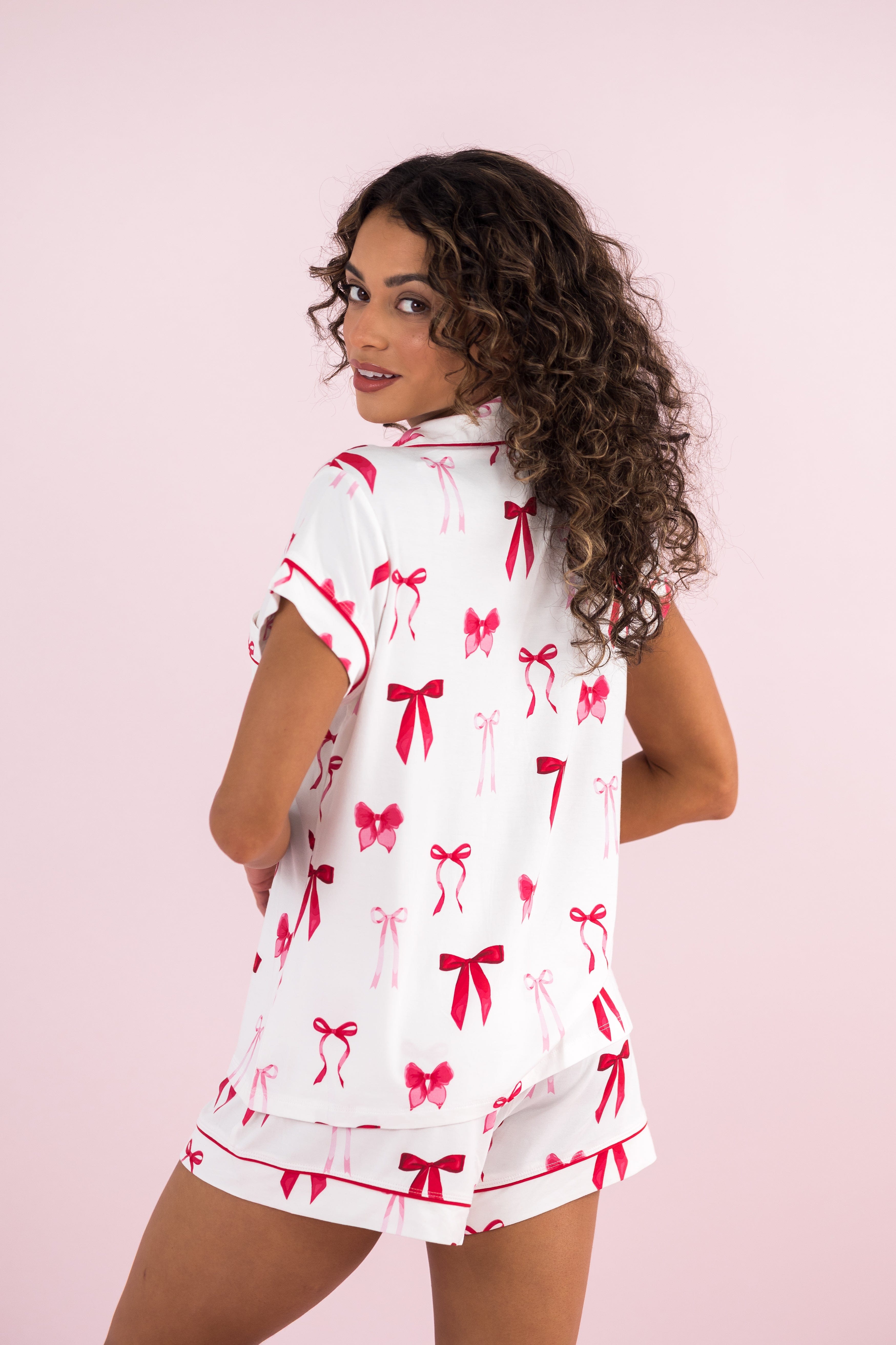 Female model wearing the Women's Short Sleeve Pajama Set in Big Love Bow with her back to the camera