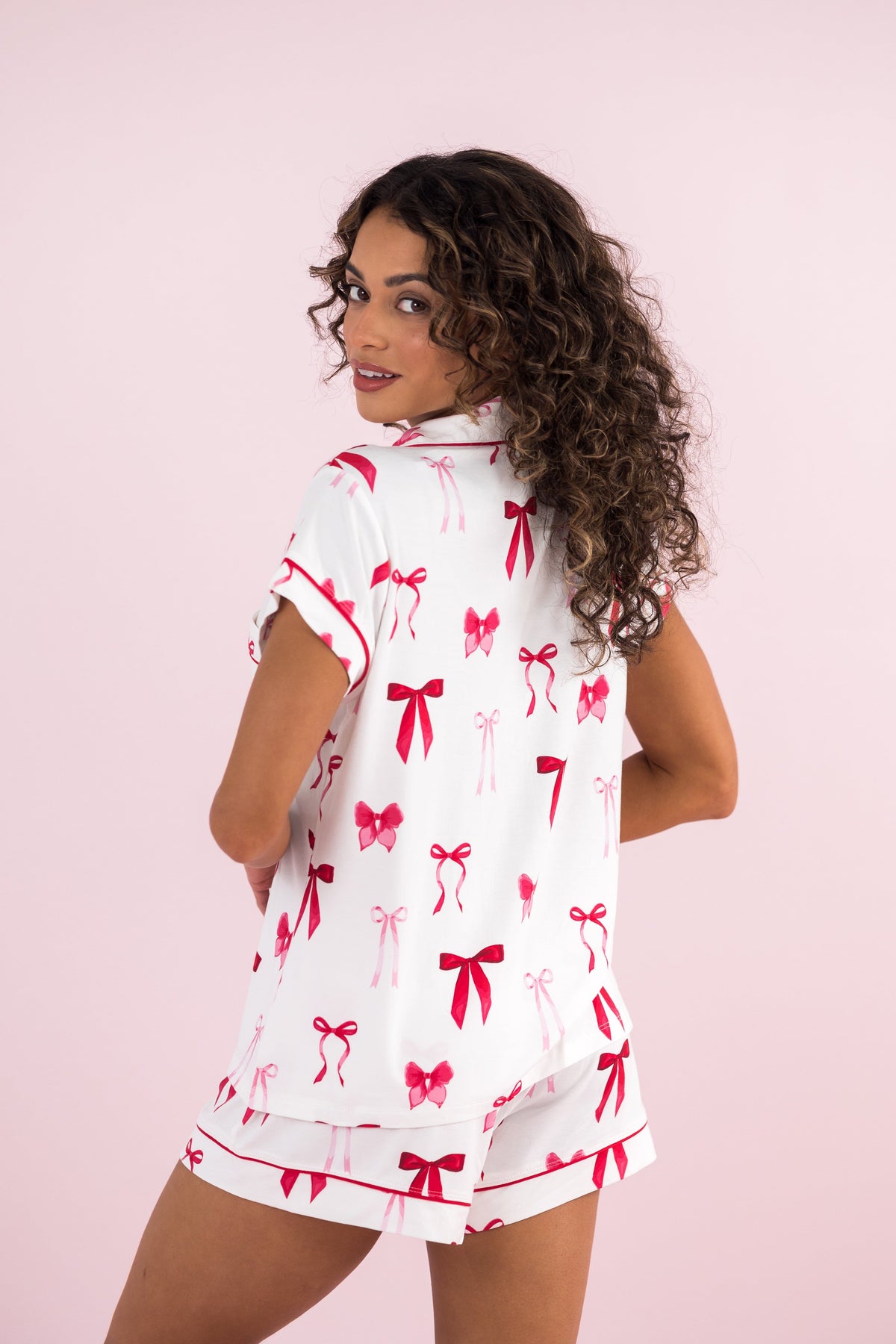 Female model wearing the Women's Short Sleeve Pajama Set in Big Love Bow with her back to the camera