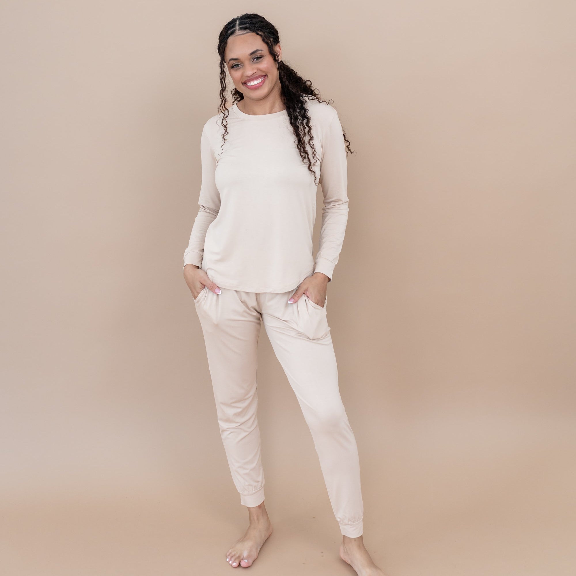 Woman wearing a matching bamboo loungewear set in a light creamy beige against a beige background