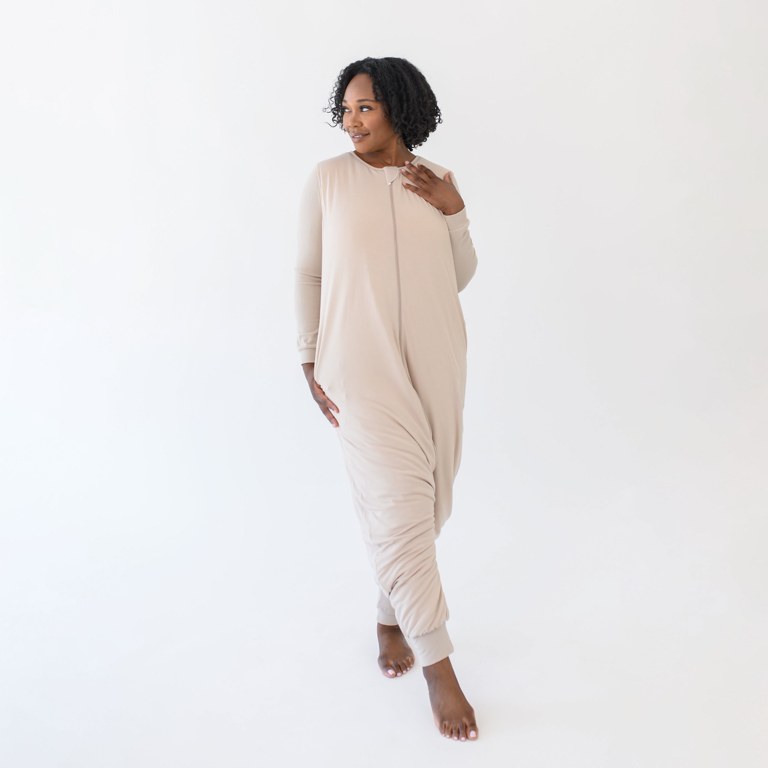 Female standing looking off to the side wearing the Adult Sleep Bag Walker in Bisque