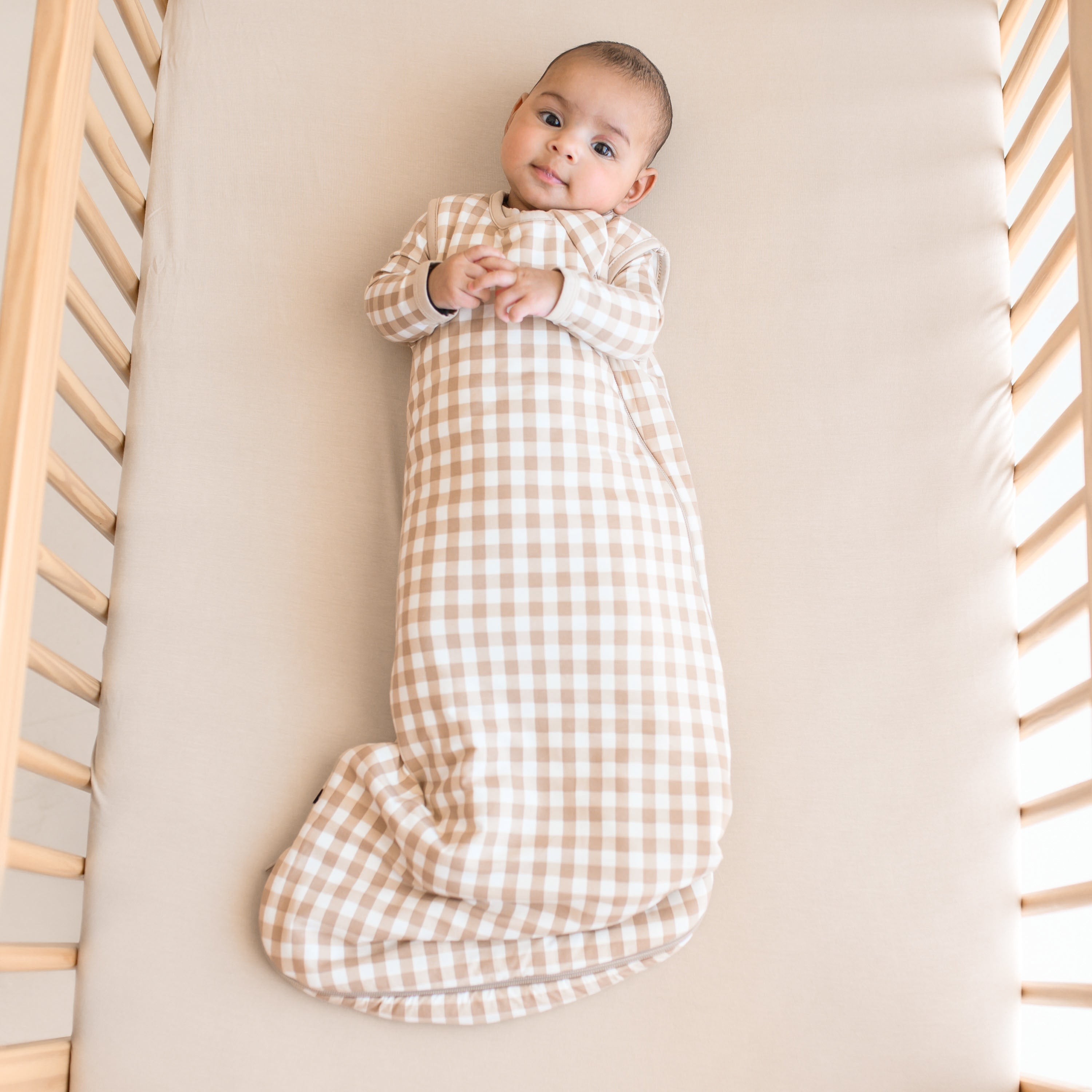 Infant wearing TOG 1.0 Sleep Bag in Gingham Bisque with matching pajamas