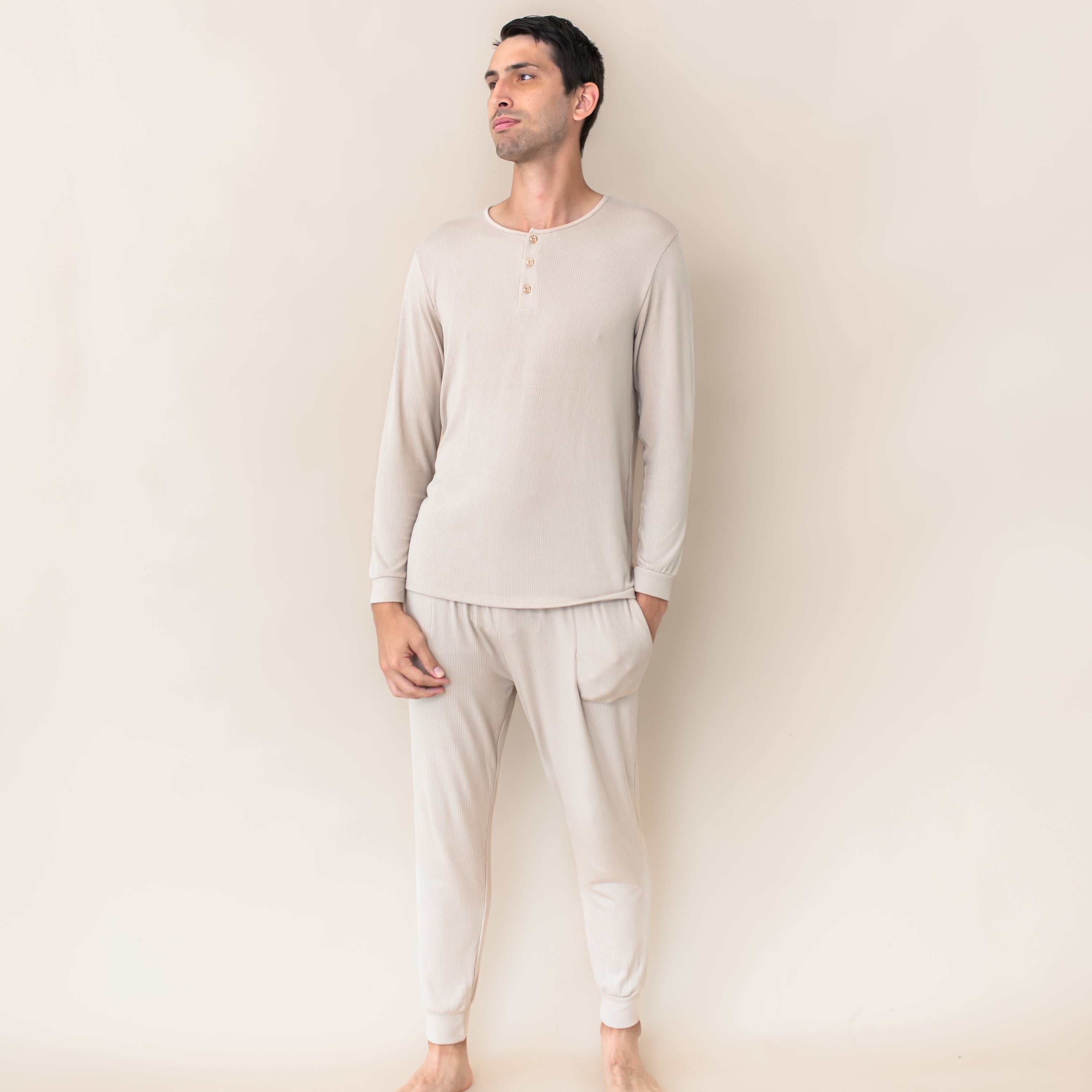 Male model wearing the Men's Ribbed Henley Set in Bisque in front of a cream colored background