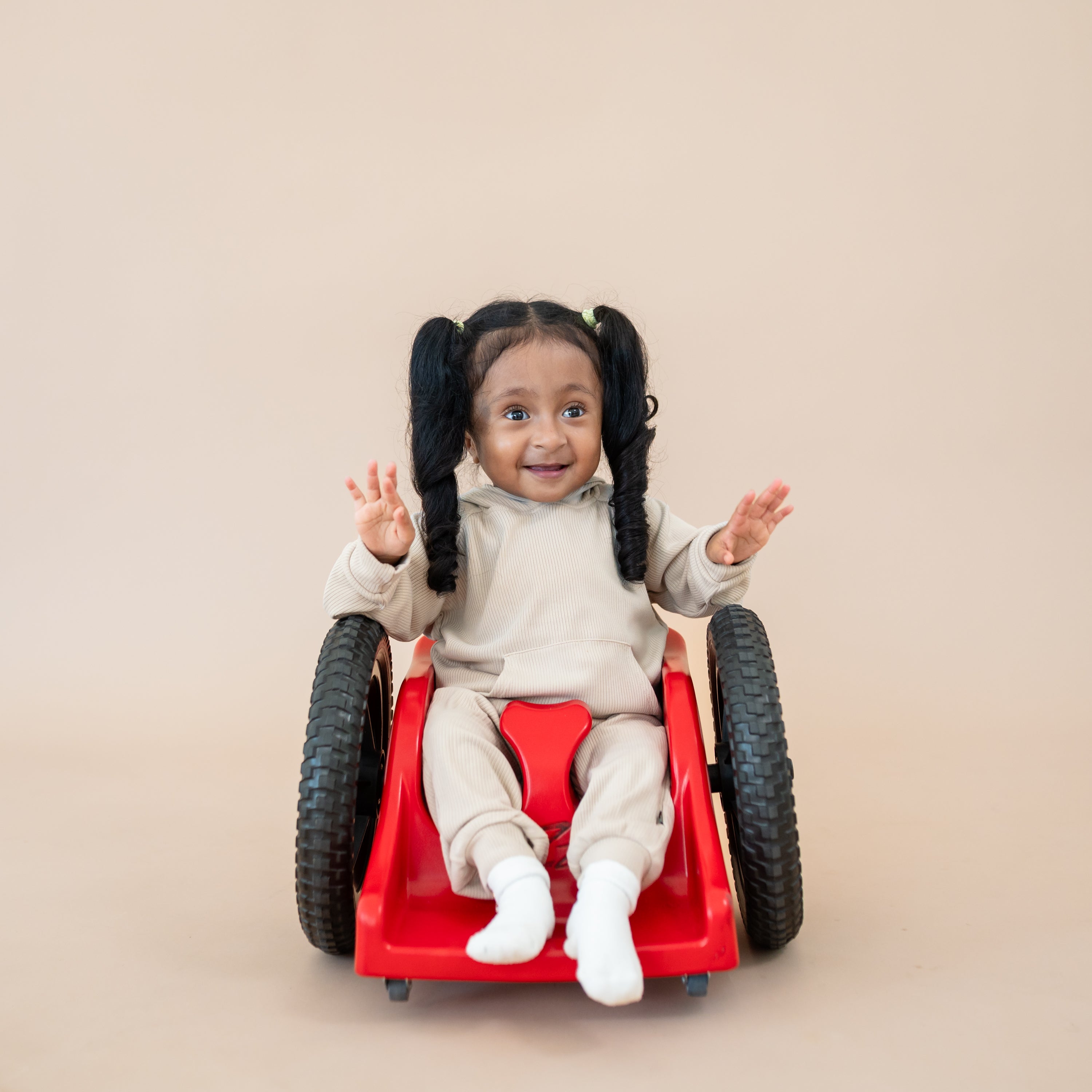 Young girl in her wheelchair wearing the Ribbed Hoodie in Bisque paired with matching ribbed jogger pants