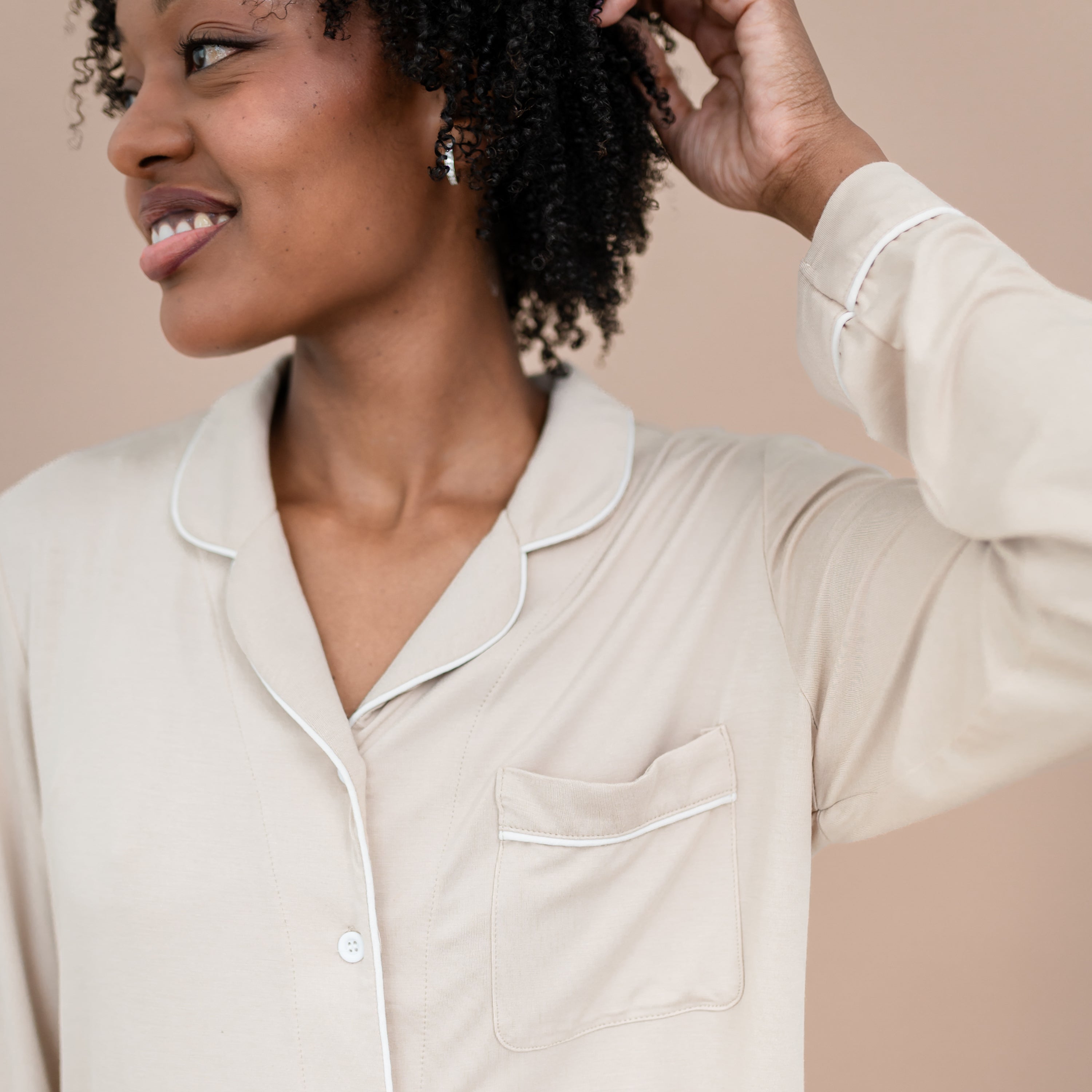 Close up of the cloud trim detail and chest pocket of the Long-Sleeved Women's Pajama Set in Bisque with Cloud Trim shown on a model