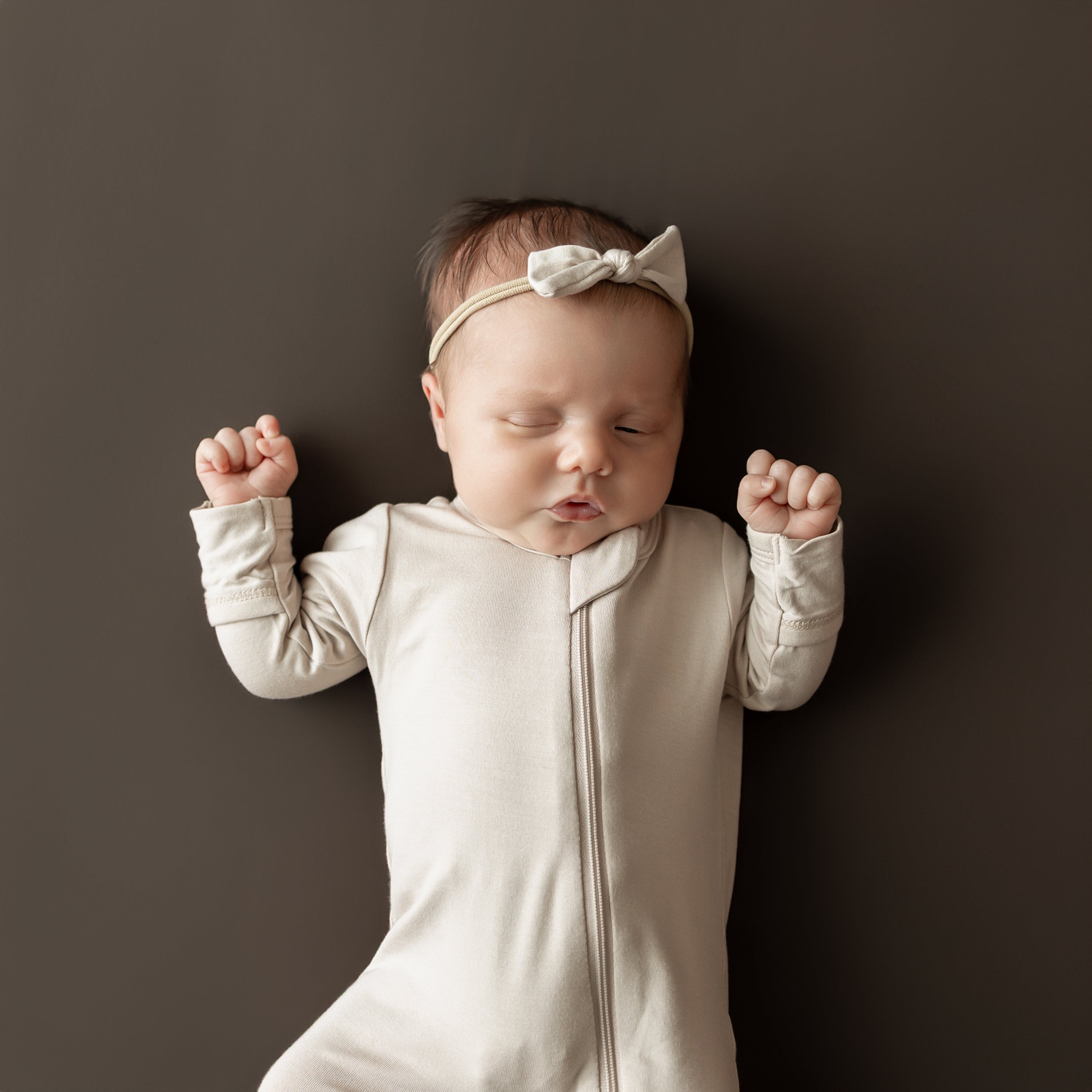 Close up of the Zippered Footie in Bisque on a sleeping infant