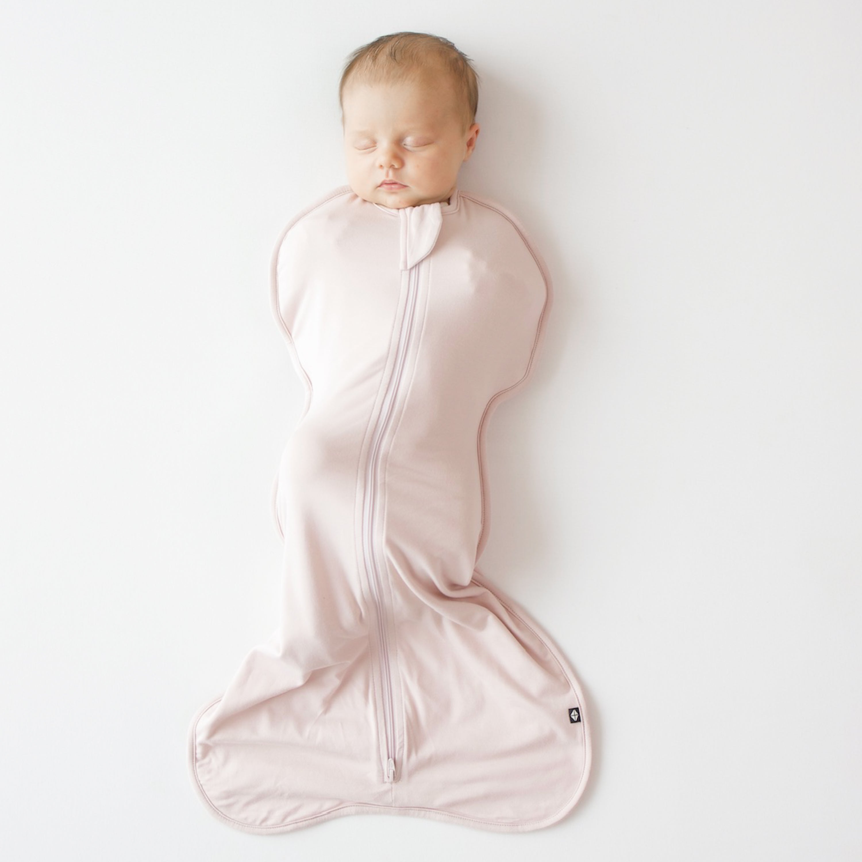 Baby sleeping in Kyte Baby Swaddle Bag in Blush 0.5