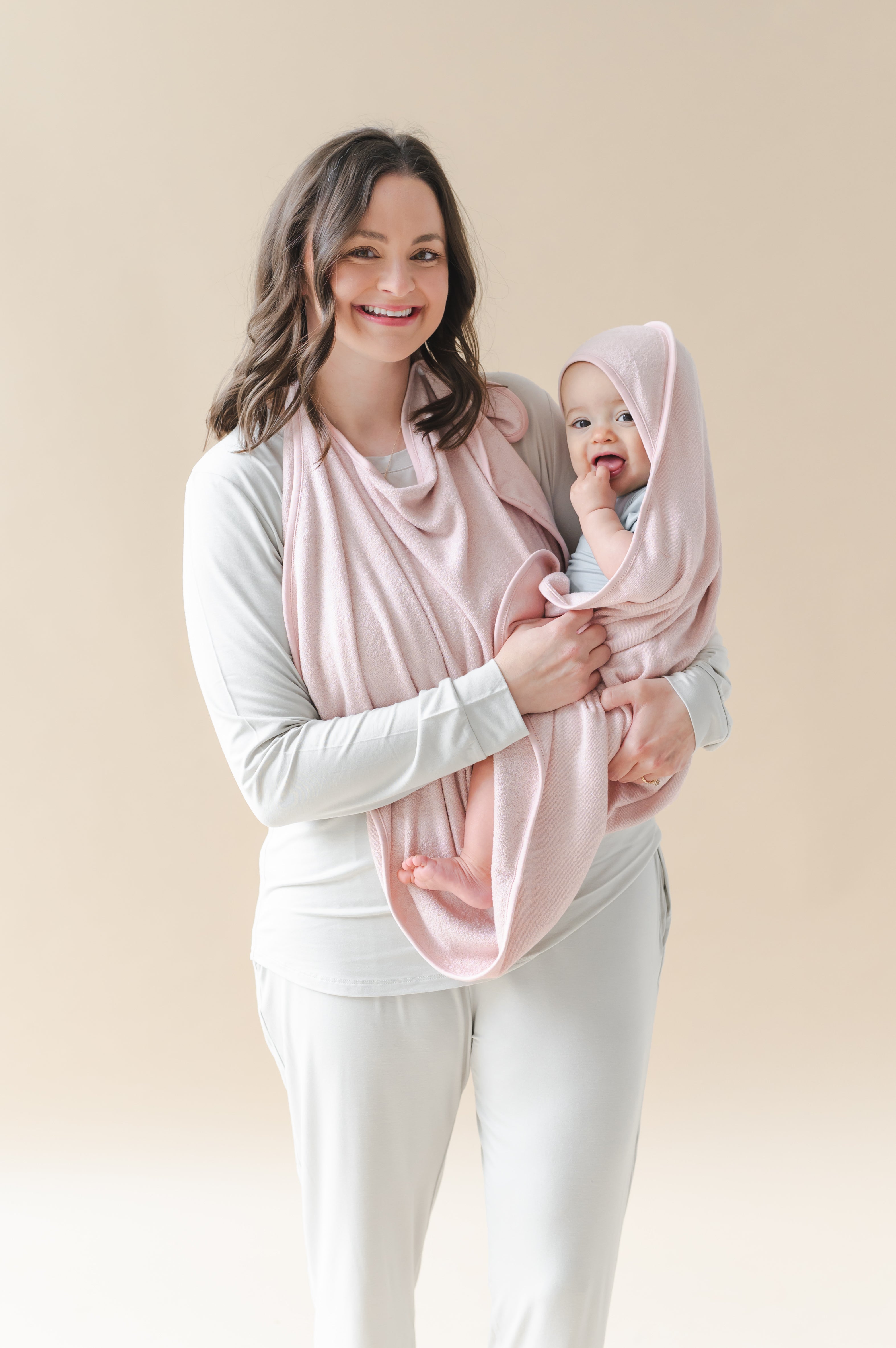 Mother holding her infant child wrapped in the Terry Apron Towel in Blush
