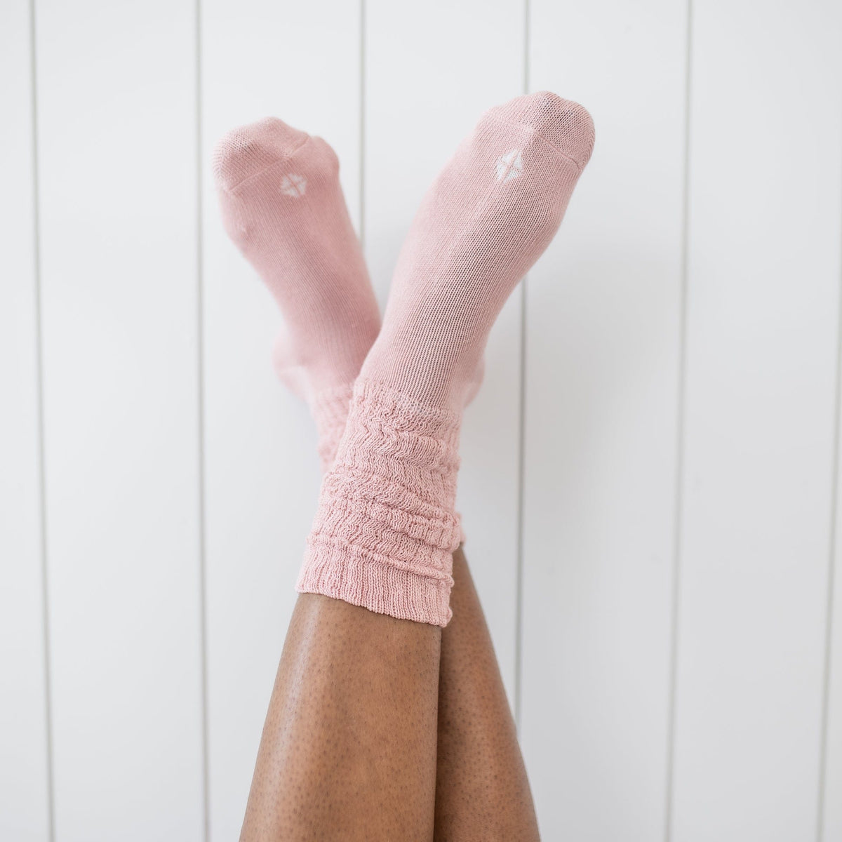 Adult Scrunch Socks in Blush being shown on a model in front of a white paneled wall