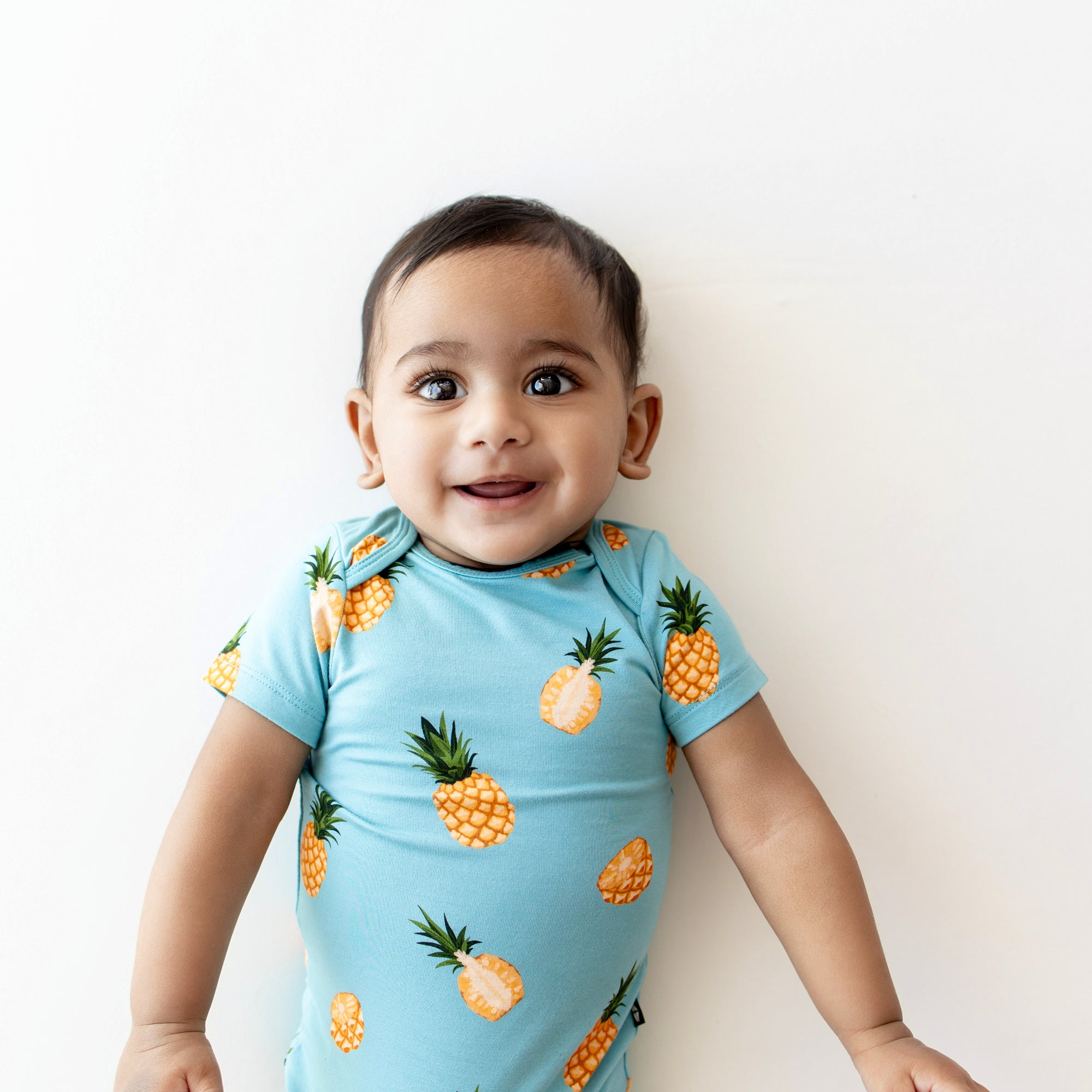 Close up of Baby modeling Bodysuit in Pineapple