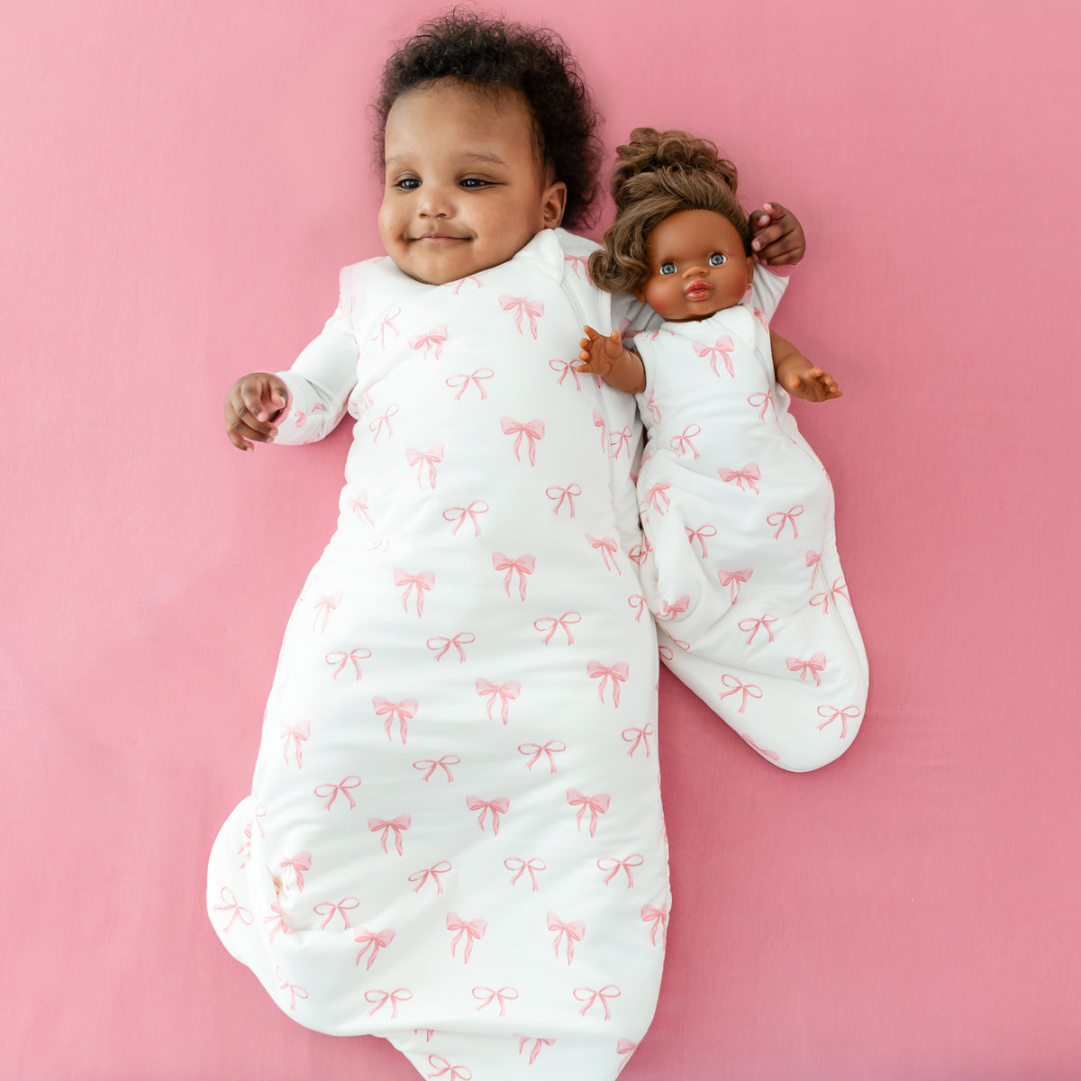 Little girl in Bow Sleep Bag with a baby doll with Baby Doll Sleep Bag in Bow