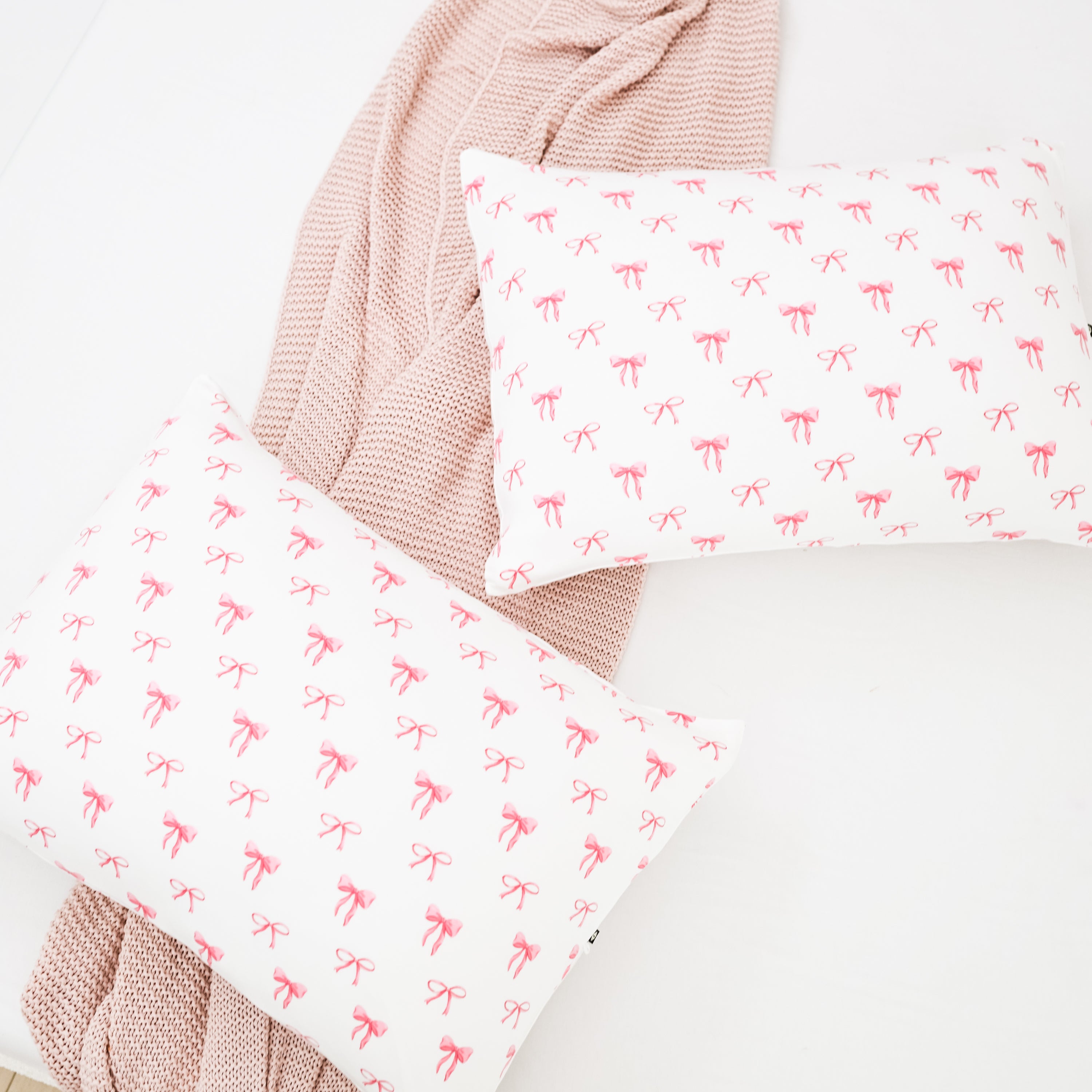 Standard Pillowcase in Bow on a bed by a knit blanket