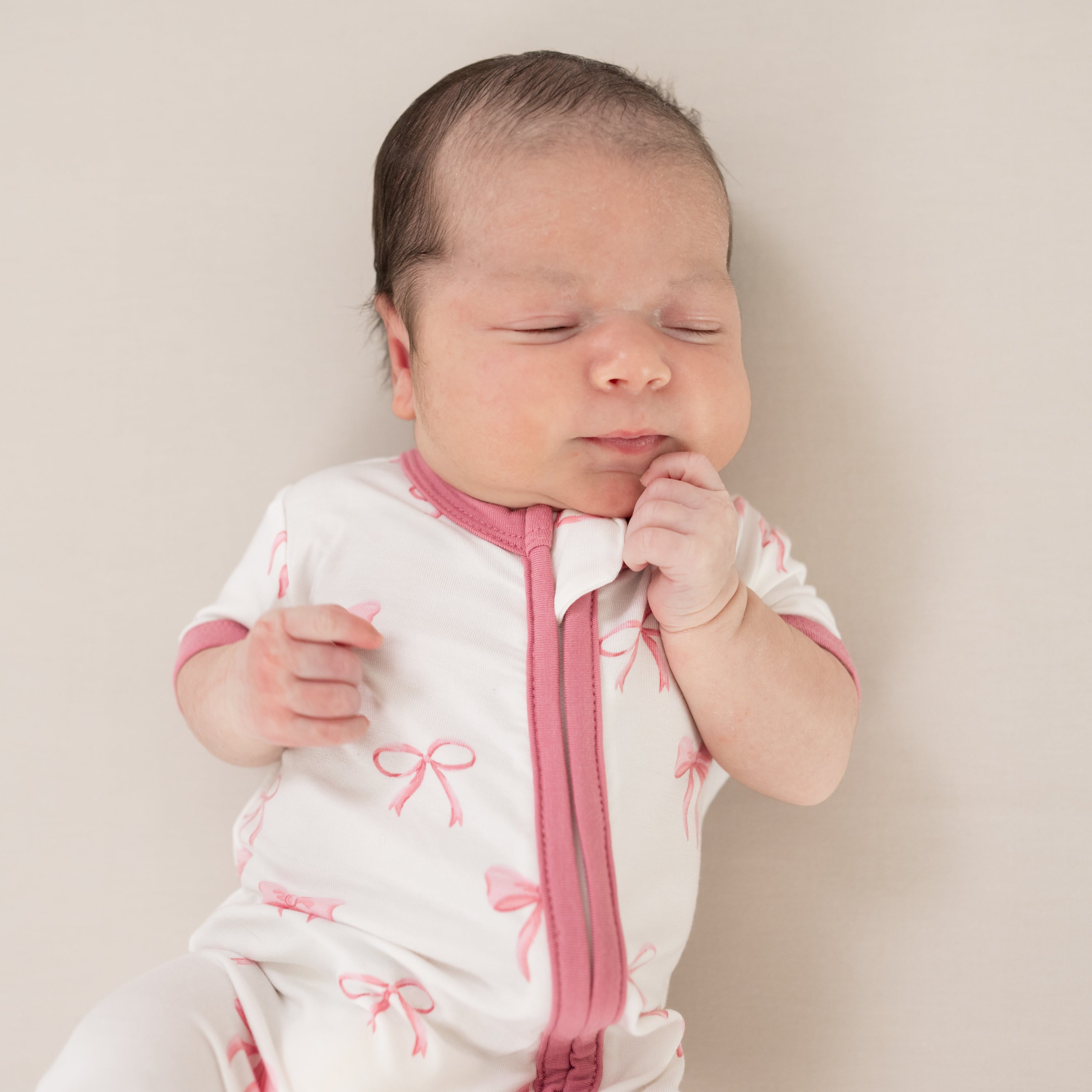 Infant wearing Kyte Baby Zippered Shortall Romper with dual zipper in Bow