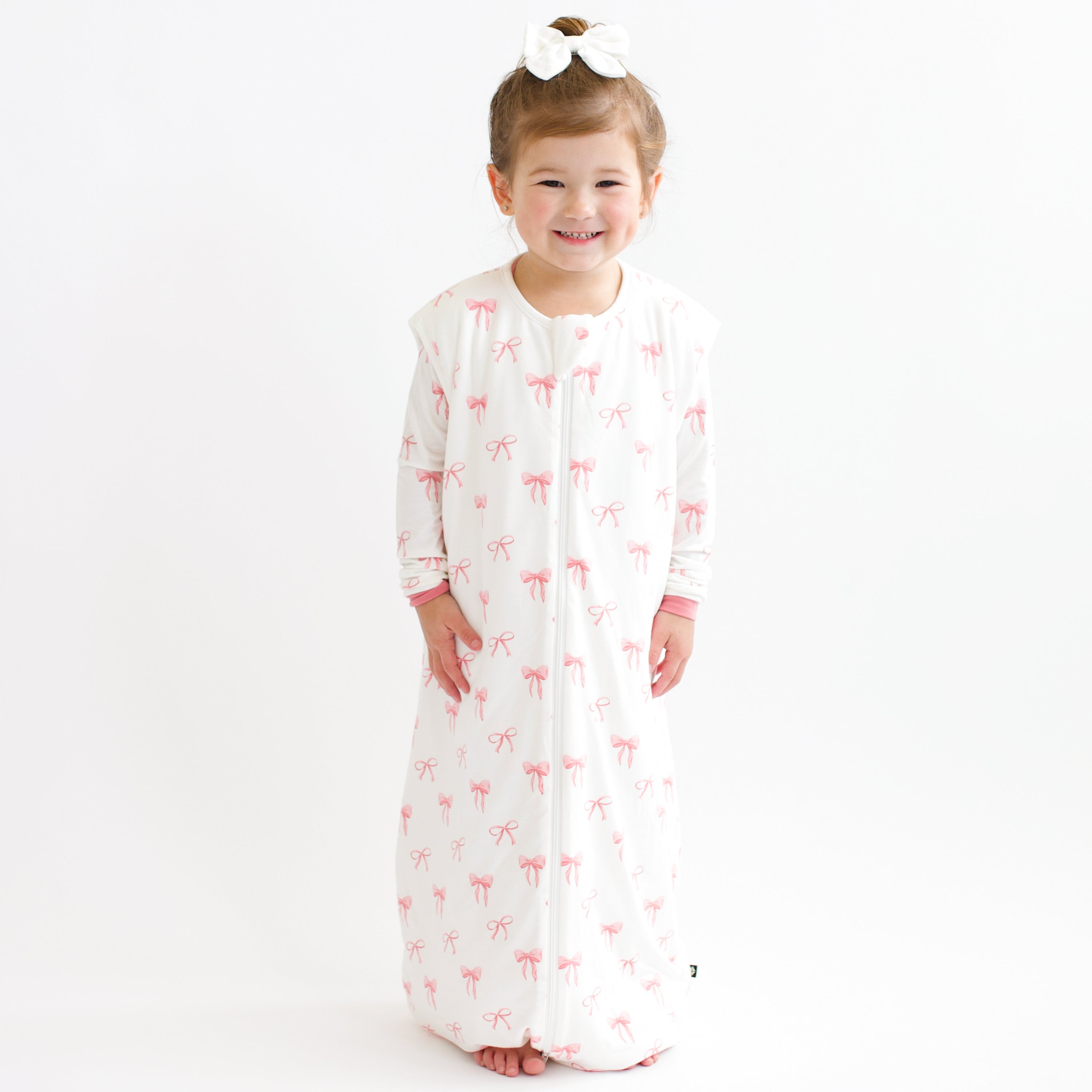 Toddler smiling modeling Sleep Bag Walker in Bow 1.0