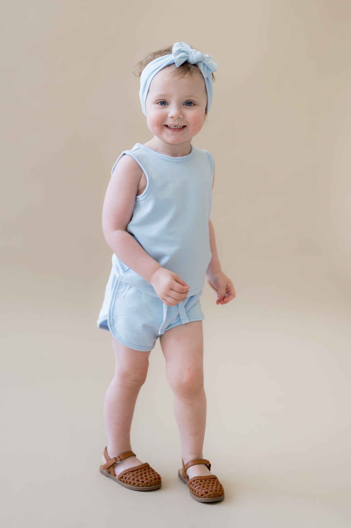 Young girl walking wearing the Tank Jogger Set in Breeze paired with a matching bow