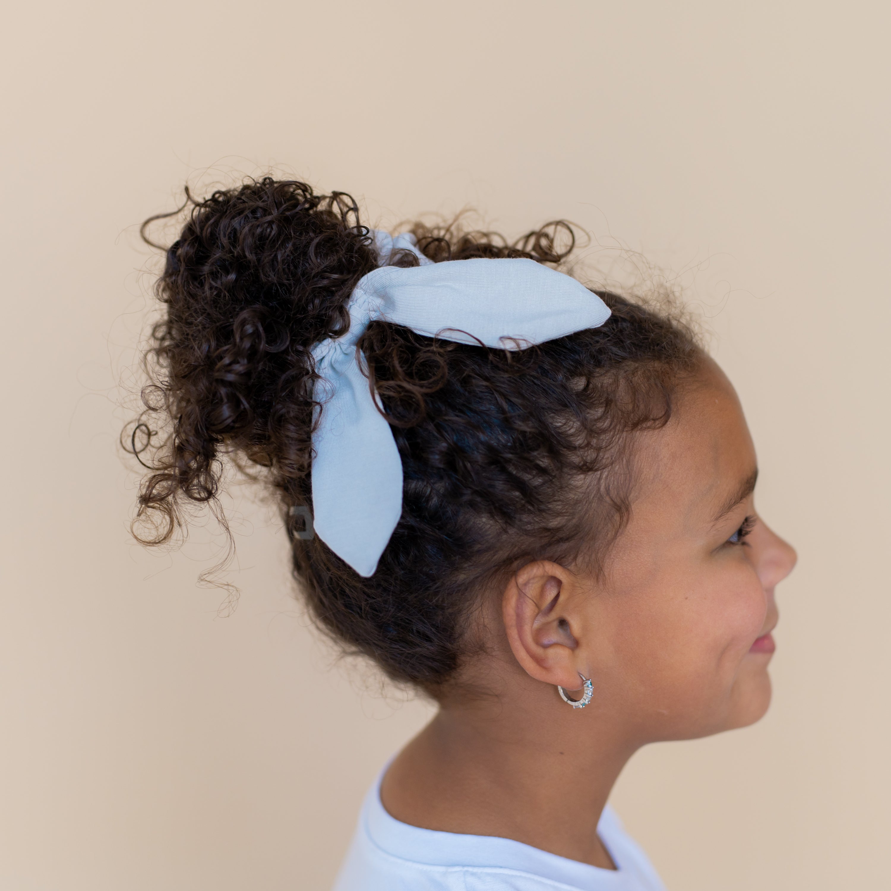 Scrunchie in Breeze shown in a girl hair tied around a hair bun