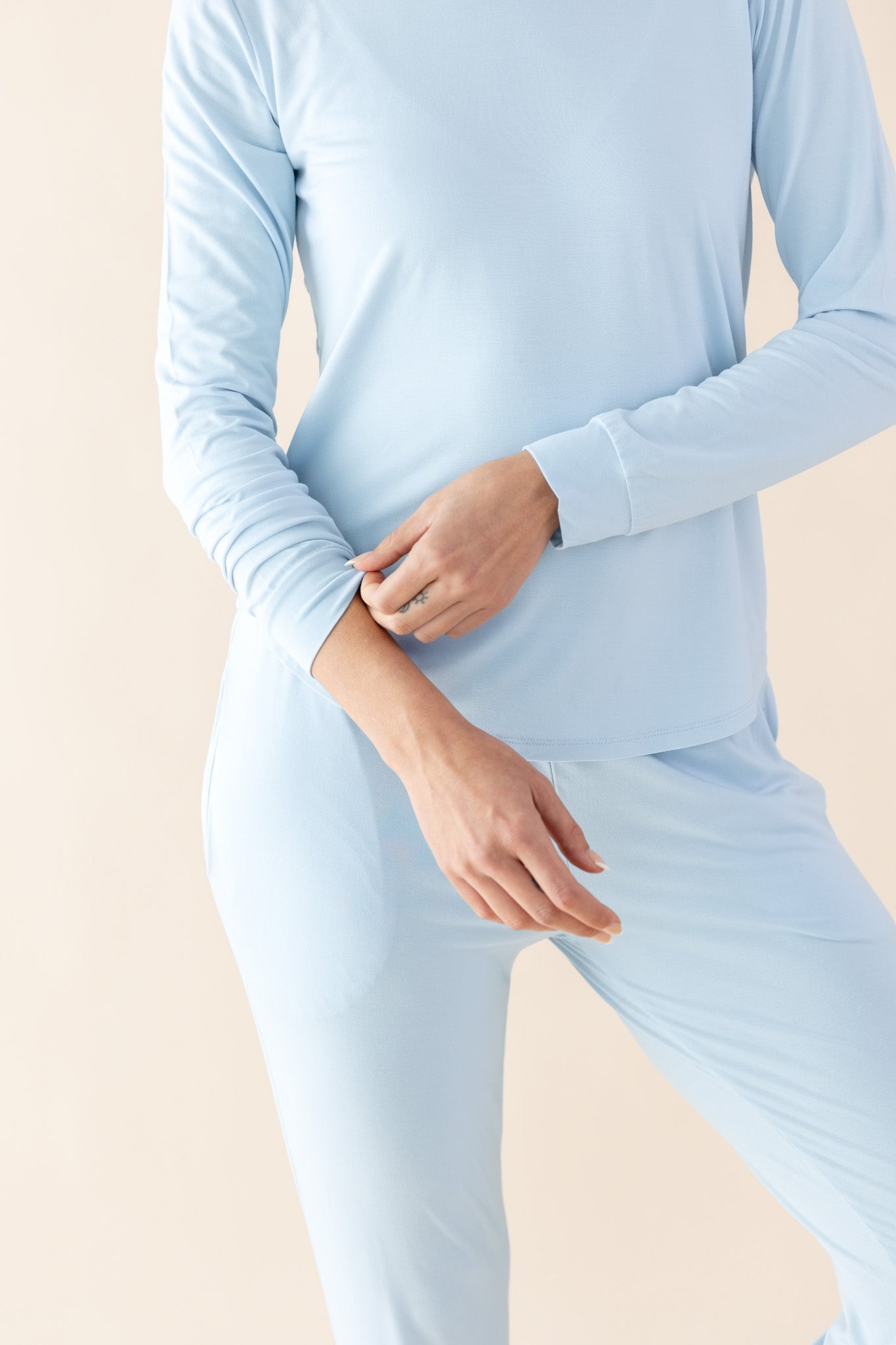 Female model wearing the Women's Jogger Pajama Set in Breeze holding the wrist cuff of the jogger top