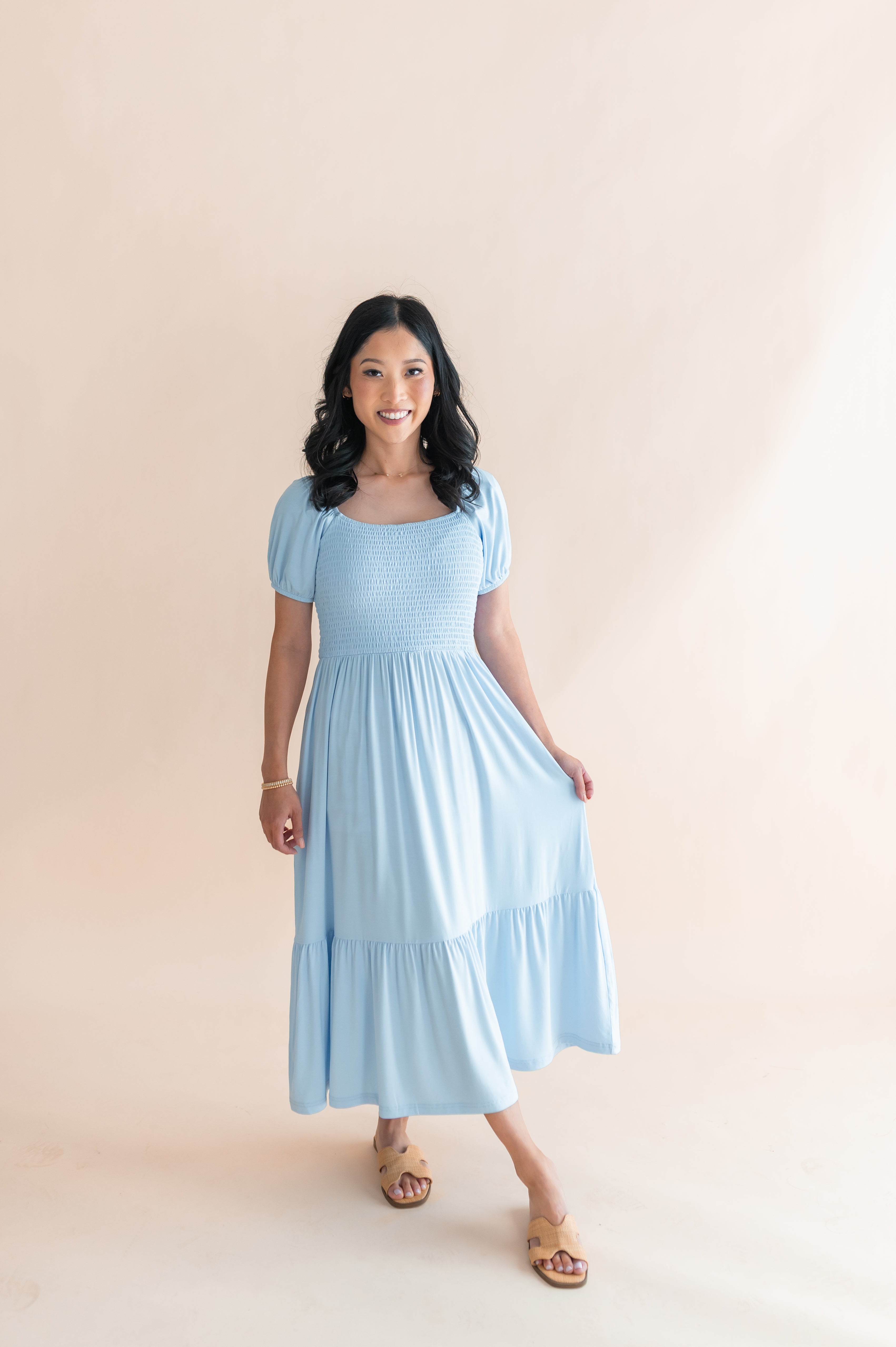 Female modeling the Women’s Smocked Dress in Breeze standing in front of a light neutral background