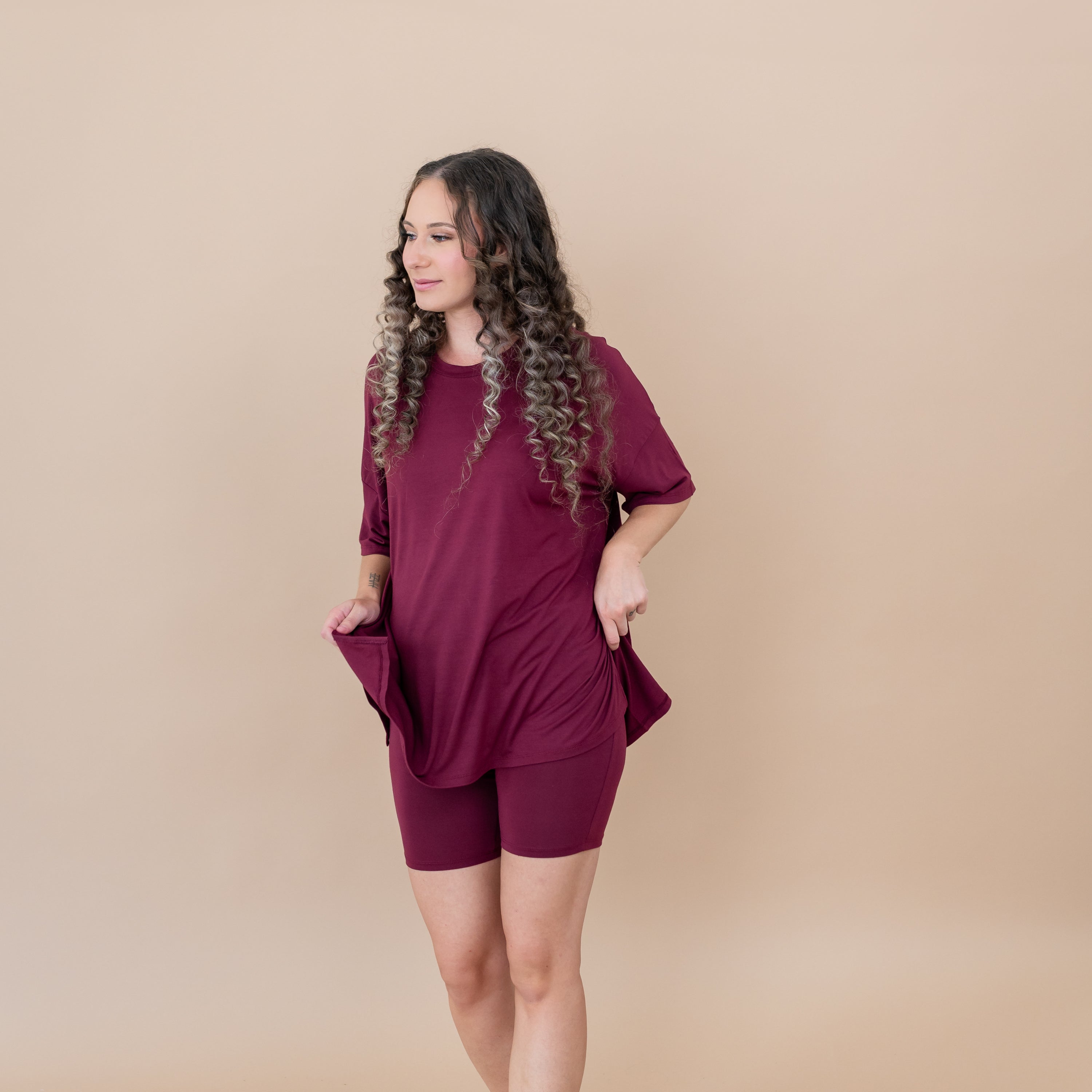 Female model standing looking off to the side wearing the Women’s Biker Short Set in Burgundy