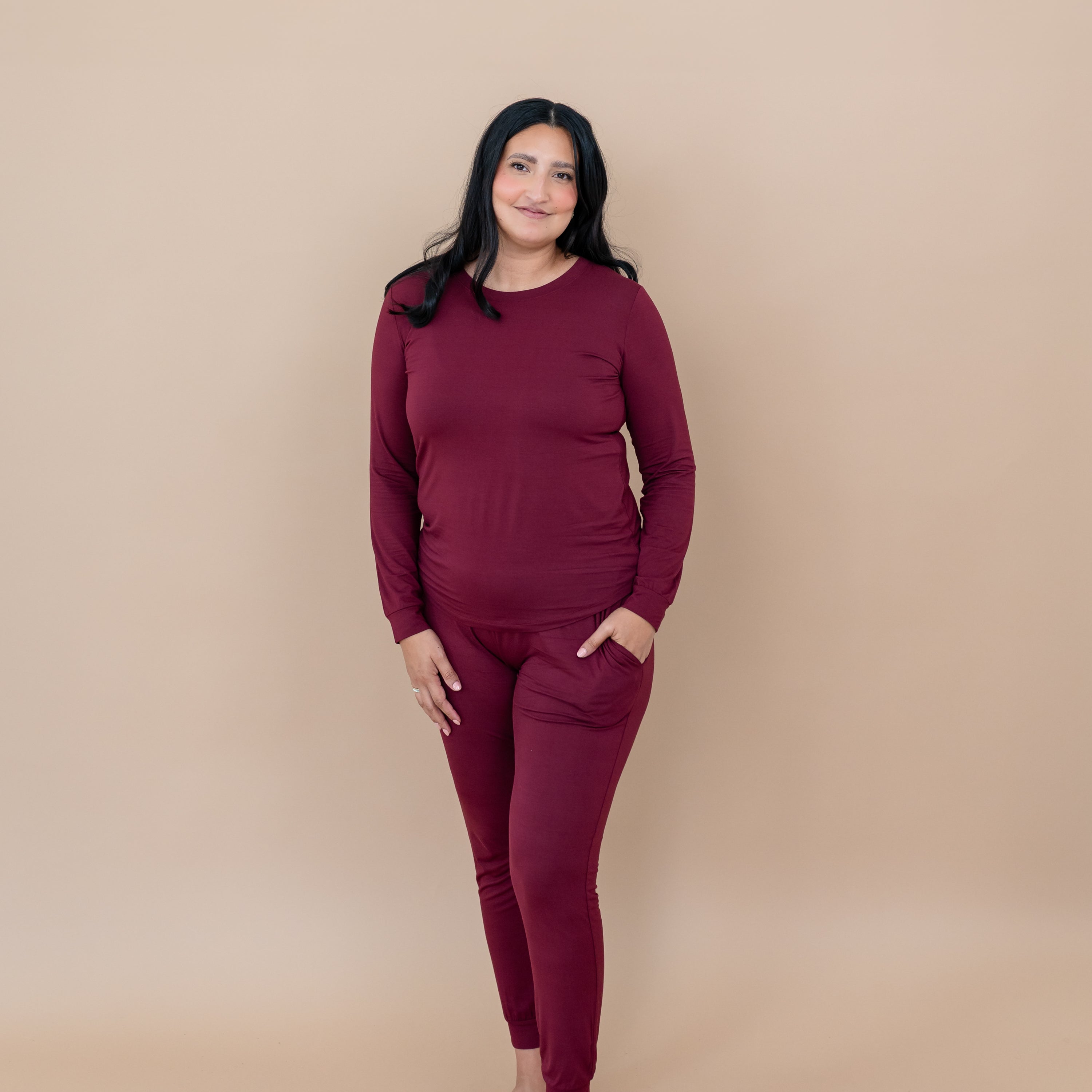 Smiling female wearing the Women's Jogger Pajama Set in Burgundy with one hand in the pants pocket
