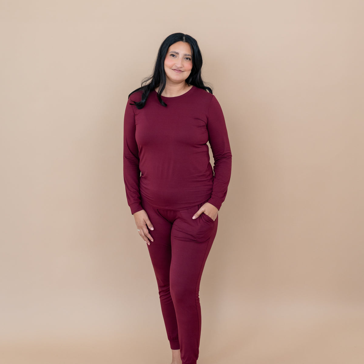 Smiling female wearing the Women's Jogger Pajama Set in Burgundy with one hand in the pants pocket