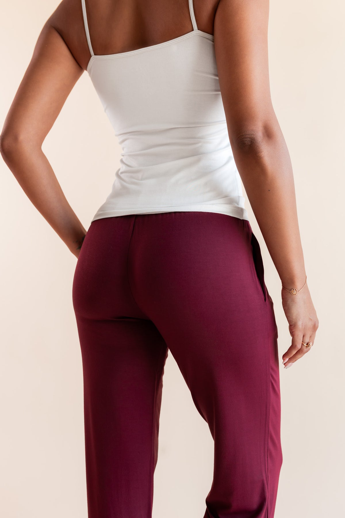 Modal showcasing back side of Women's Lounge Pants in Burgundy under white camisole on a beige background
